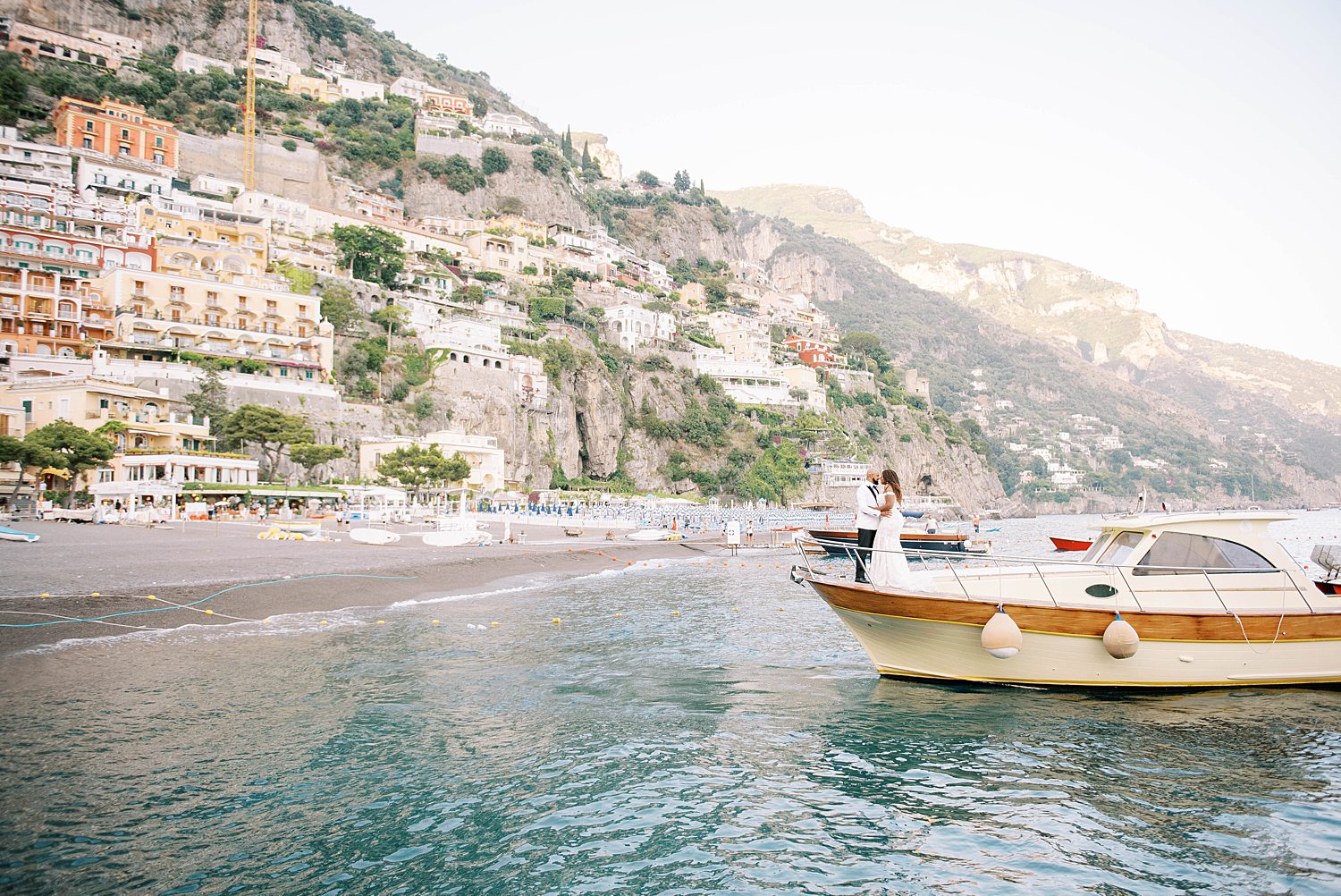 bride nd groom pose on boat along Amalfi Coast