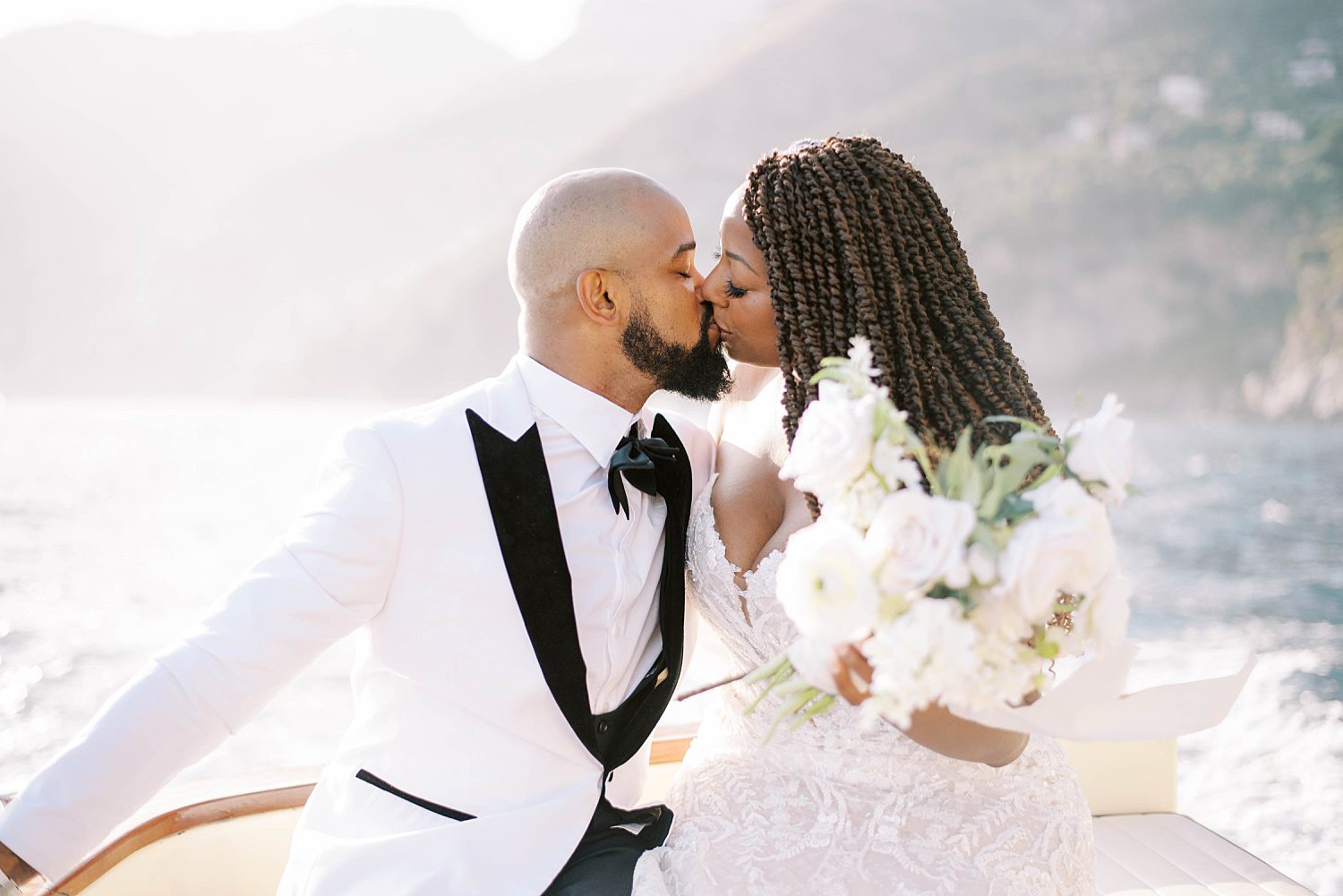 newlyweds kiss on front of boat during elopement in Italy