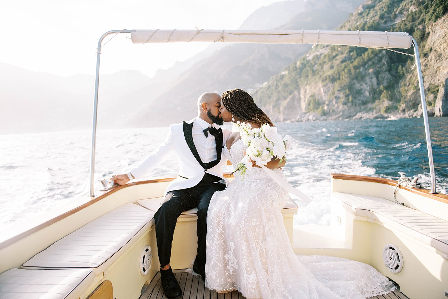 bride and groom ride on back of boat during elopement