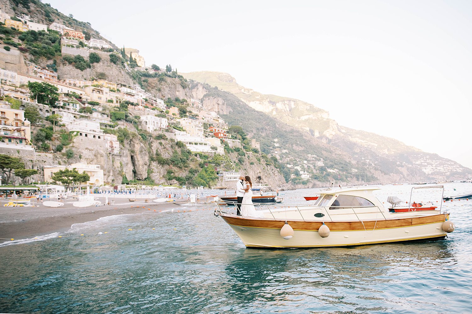 bride and groom pose on boat during Amalfi Coast elopement