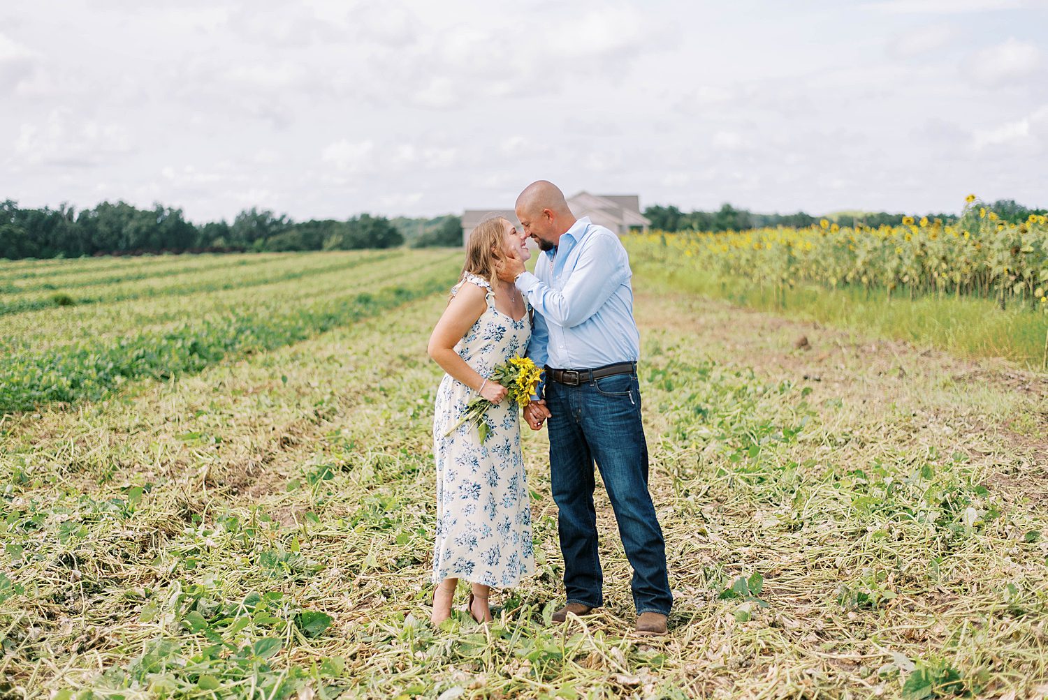 bride and groom kiss in field during Tampa engagement session