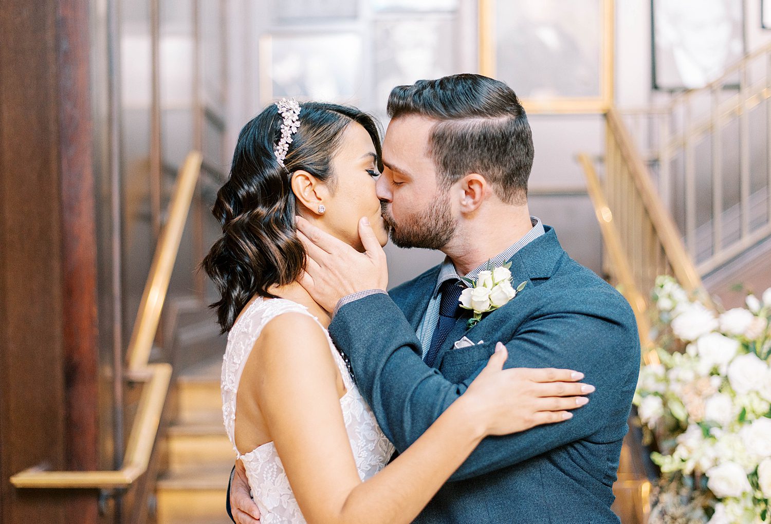 groom holds bride's cheek kissing her in Tampa FL