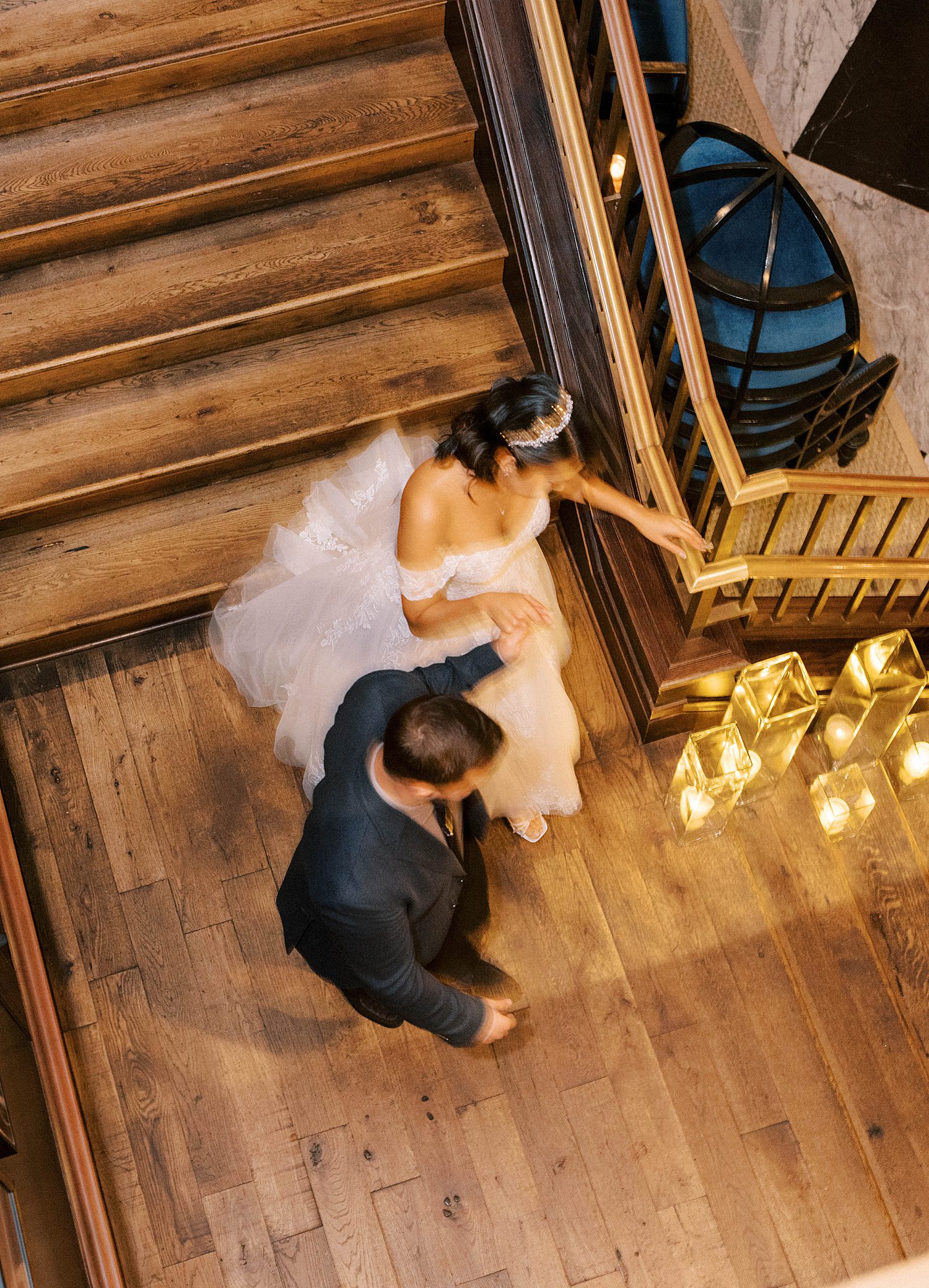 groom leads bride down steps inside Oxford Exchange