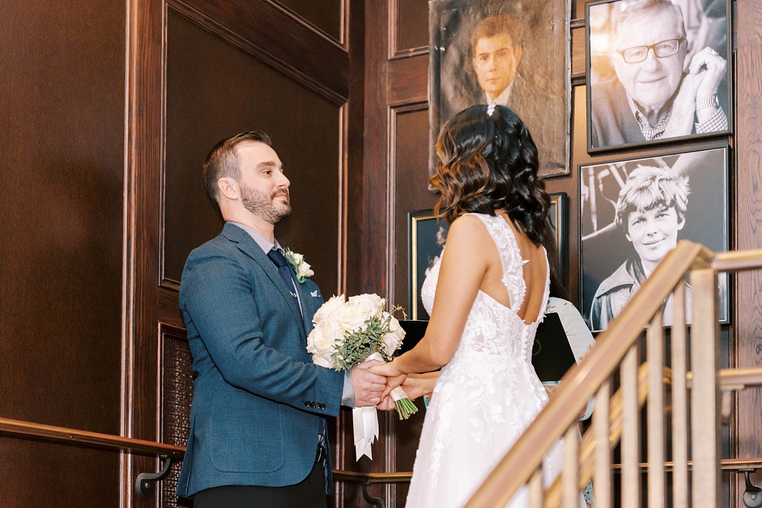 groom looks at bride during ceremony on steps at Oxford Exchange