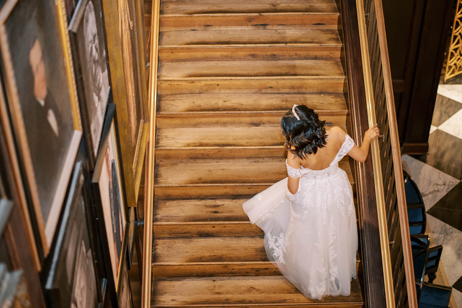 bride walks up steps looking over shoulder at dress