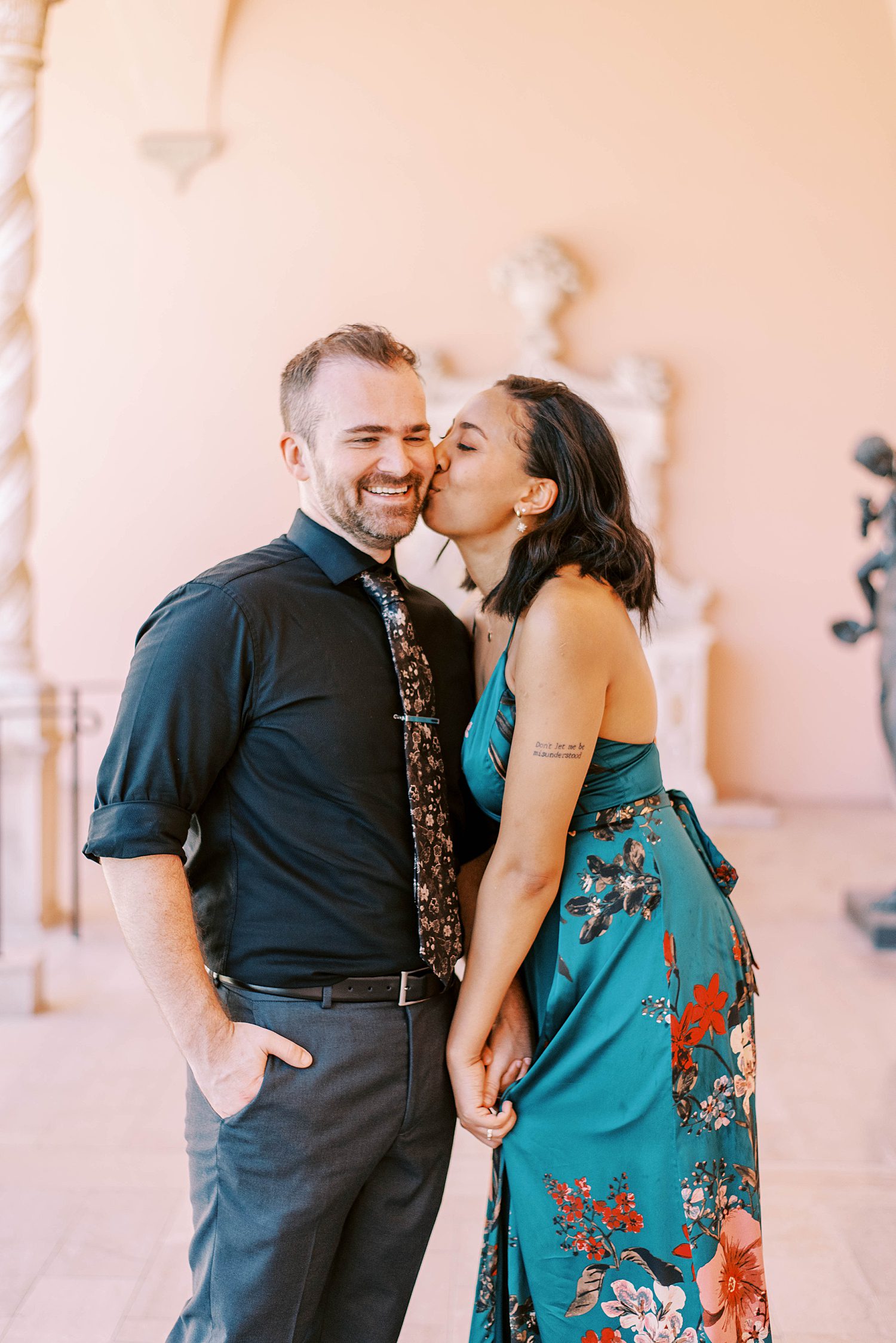 woman kisses her fiancee's cheek during the Ringling Museum engagement session