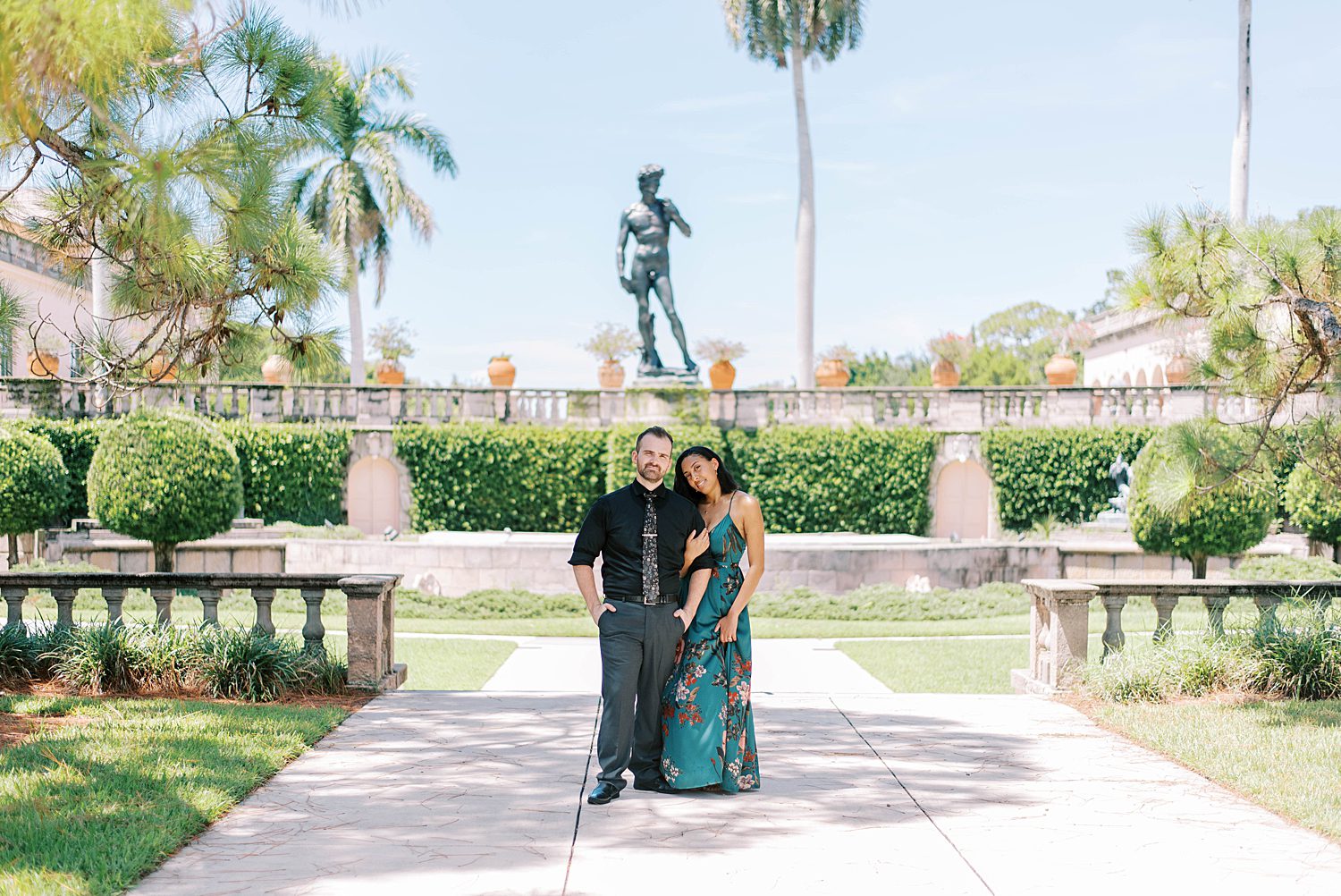 engaged couple hugs in garden at the Ringling Museum
