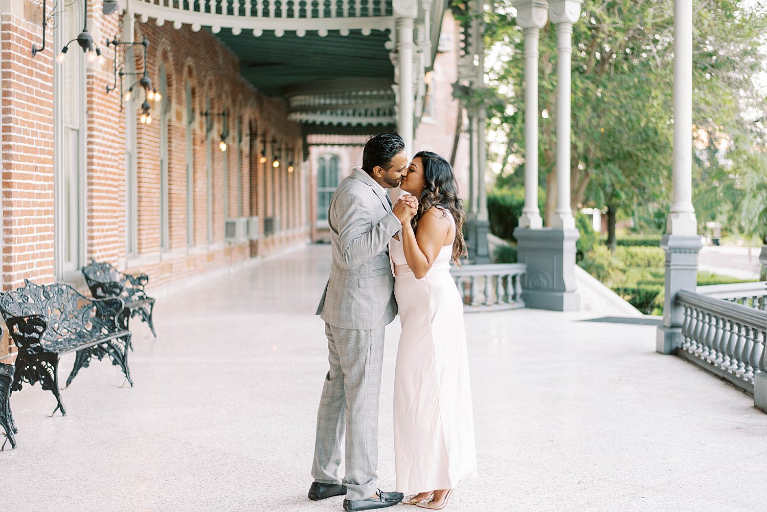 engaged couple kiss along walkway at University of Tampa