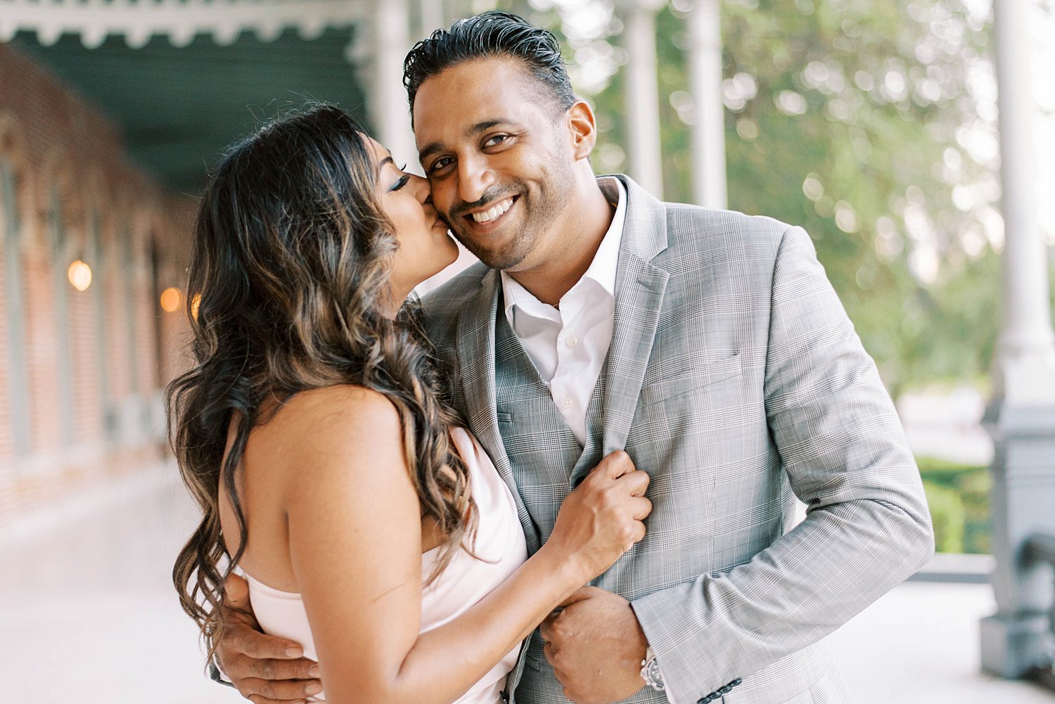 woman leans to kiss fiancee during University of Tampa engagement session 