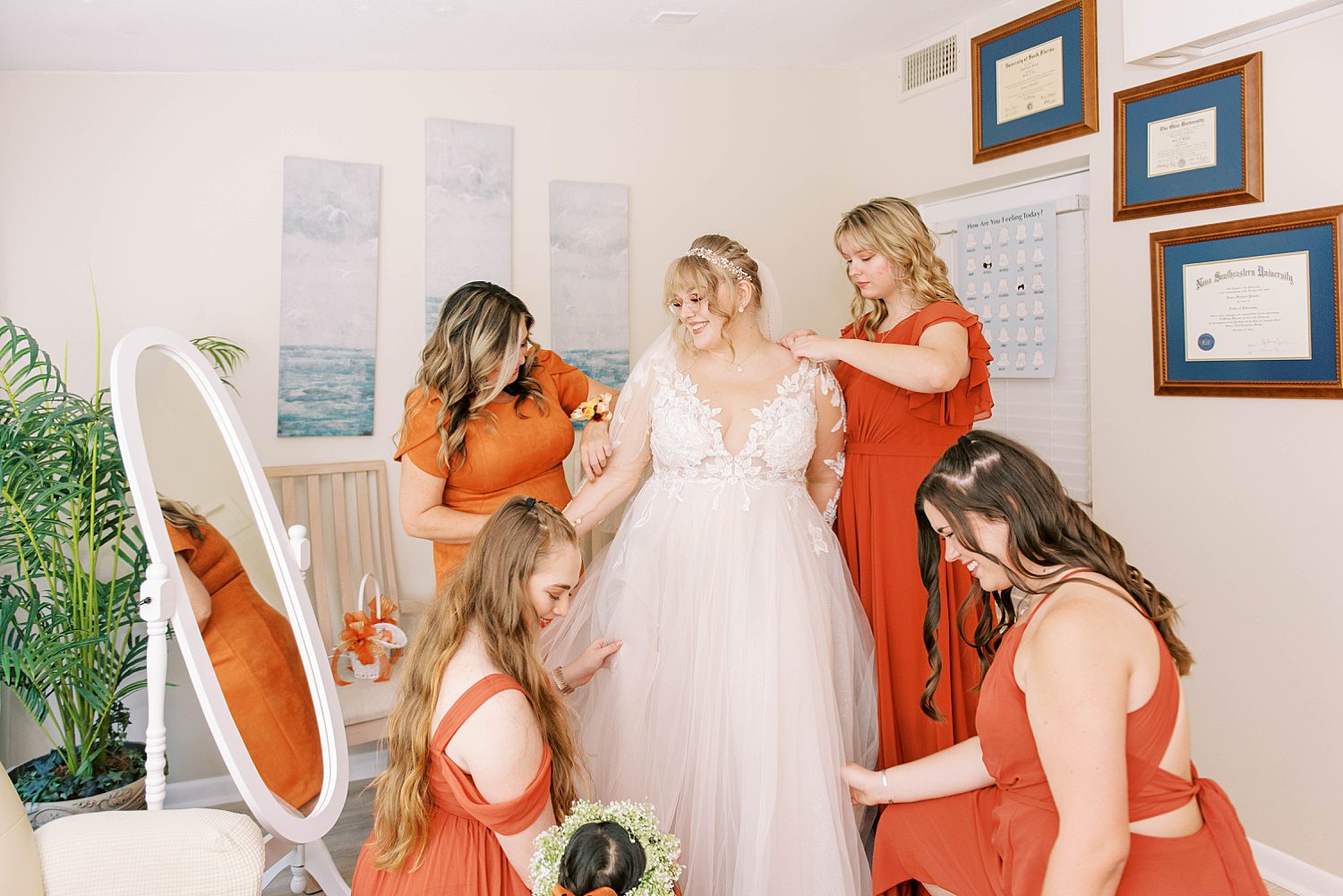 bridesmaids in burnt orange help bride prepare for Events Under the Oaks wedding