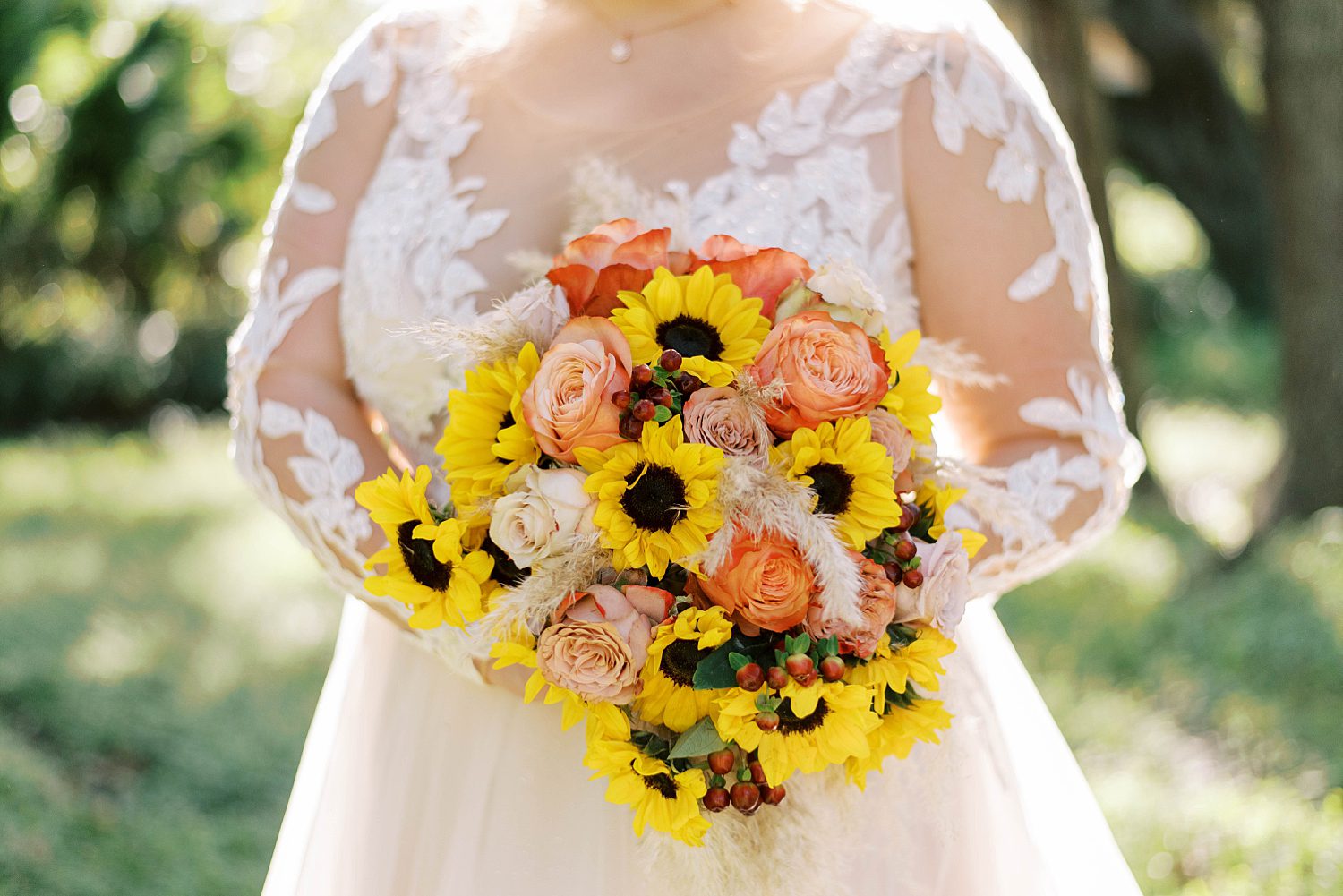 bride holds fall bouquet with yellow and orange flowers at Events Under the Oaks