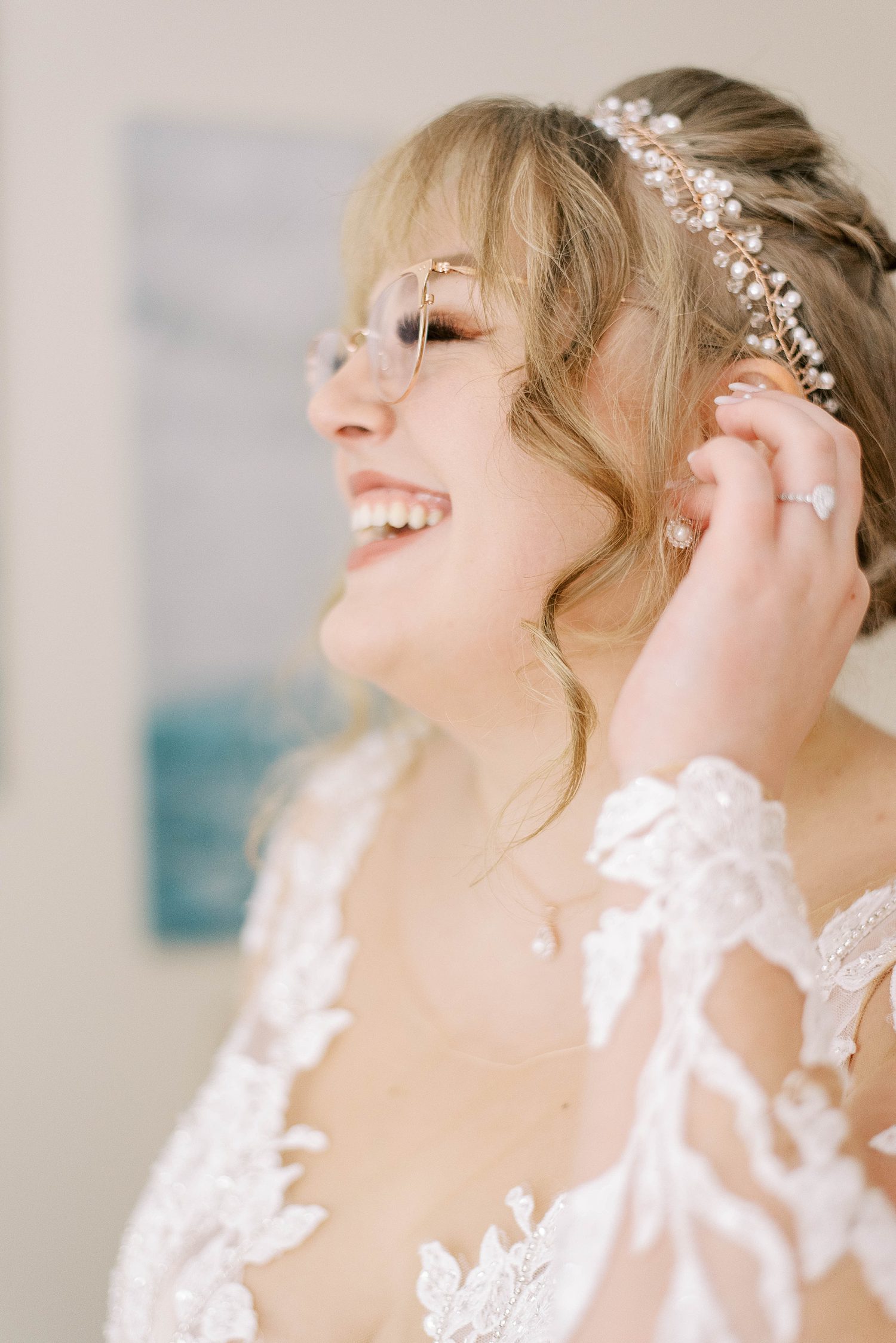bride laughs adjusting tiara before fall wedding at Events Under the Oaks