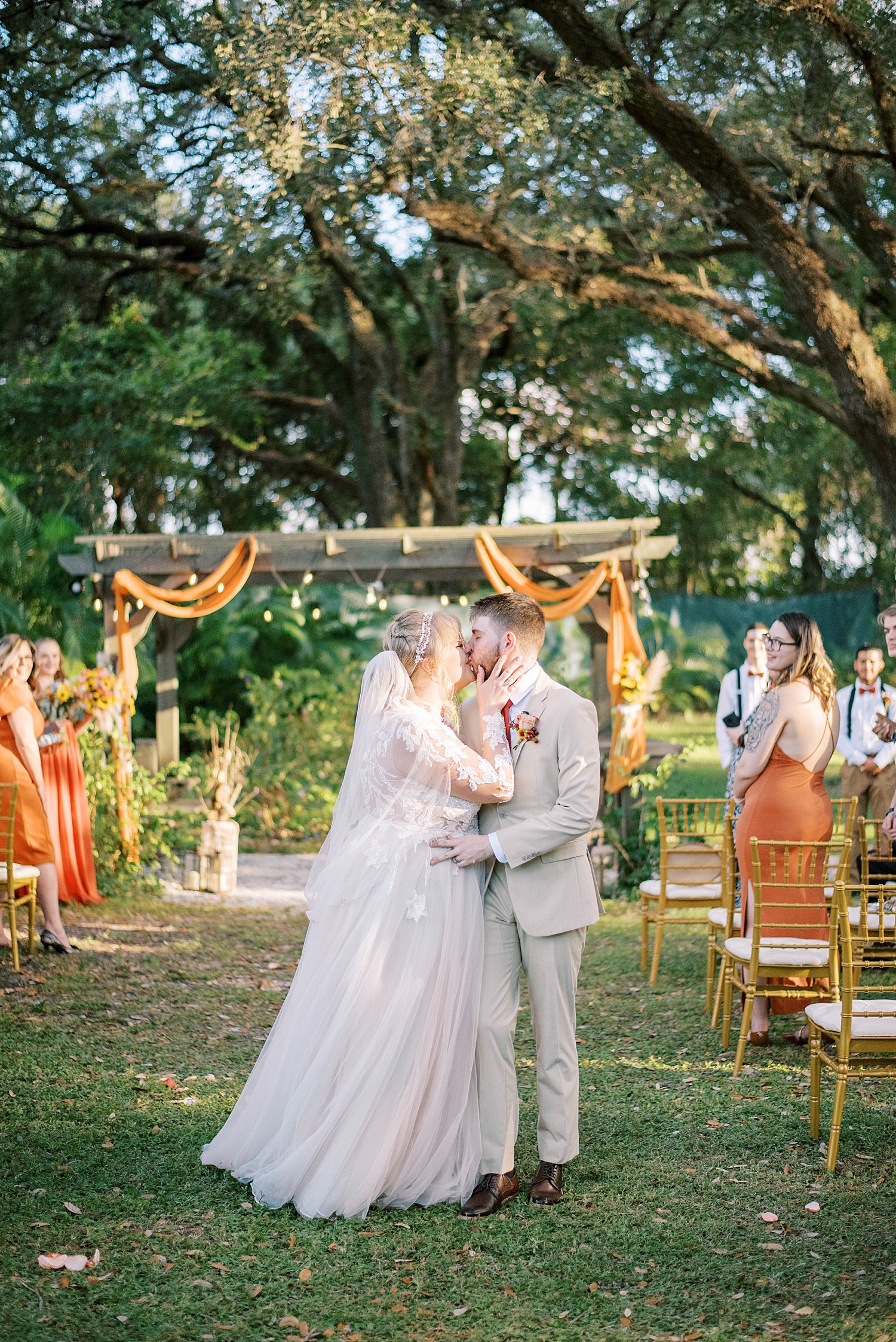 bride and groom kiss in aisle after ceremony at Events Under the Oaks