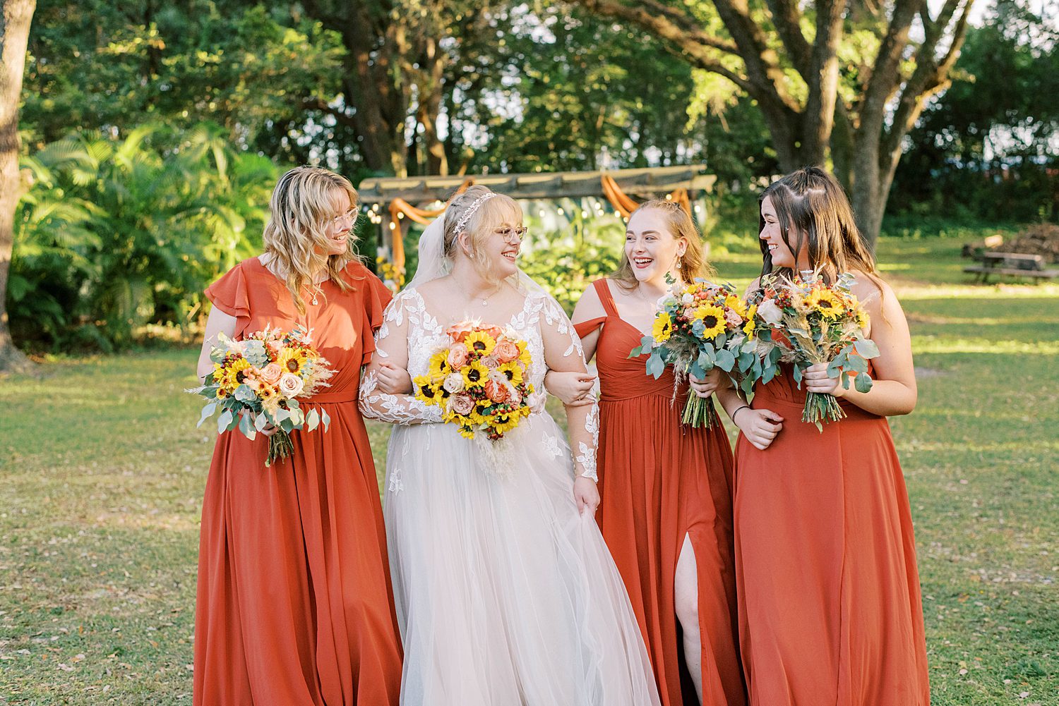 bride poses with bridesmaids in burnt orange gown 