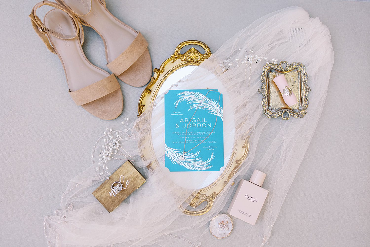 blue wedding invitation rests on gold tray for FL wedding day