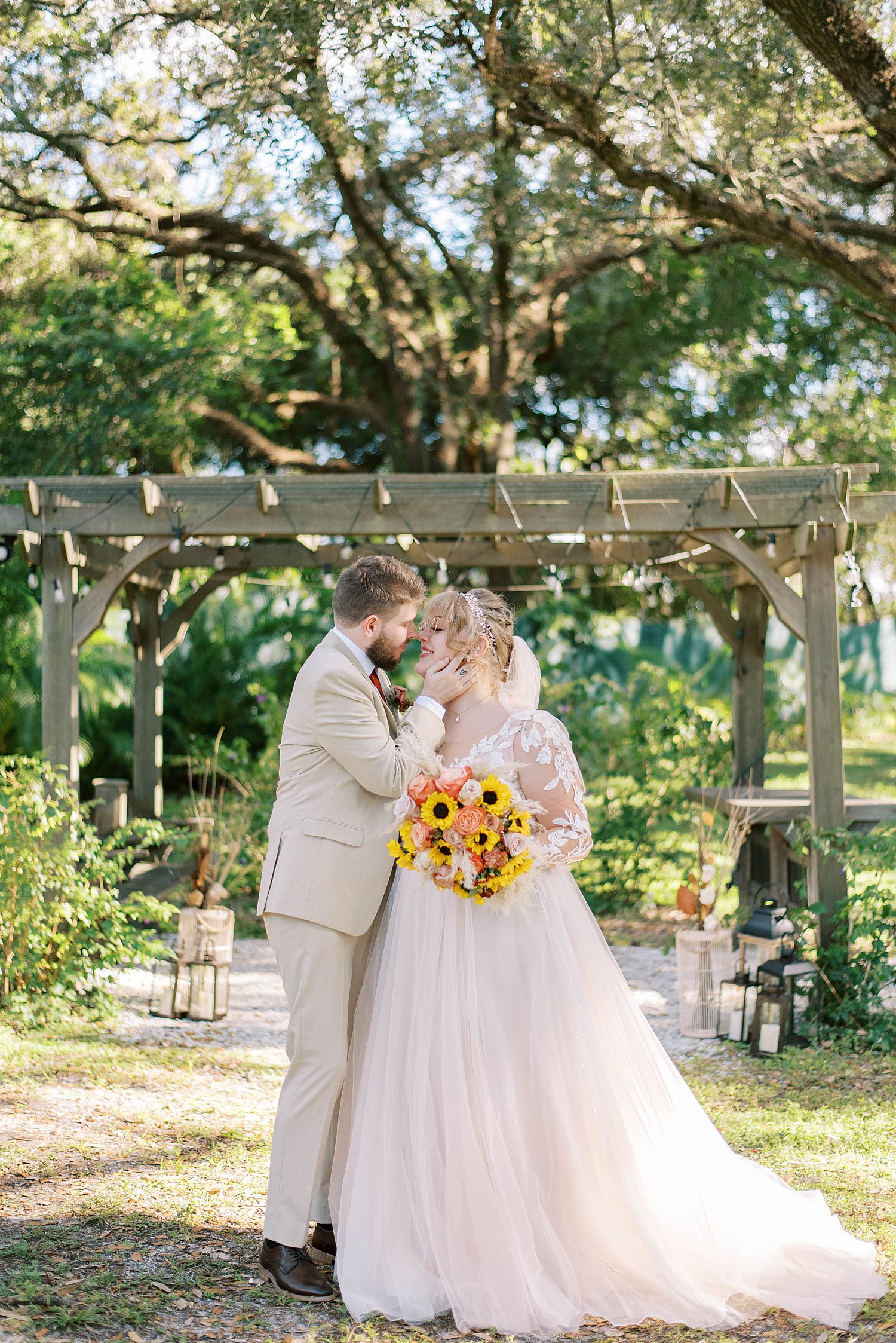 bride and groom pose under wooden arbor at Events Under the Oaks 