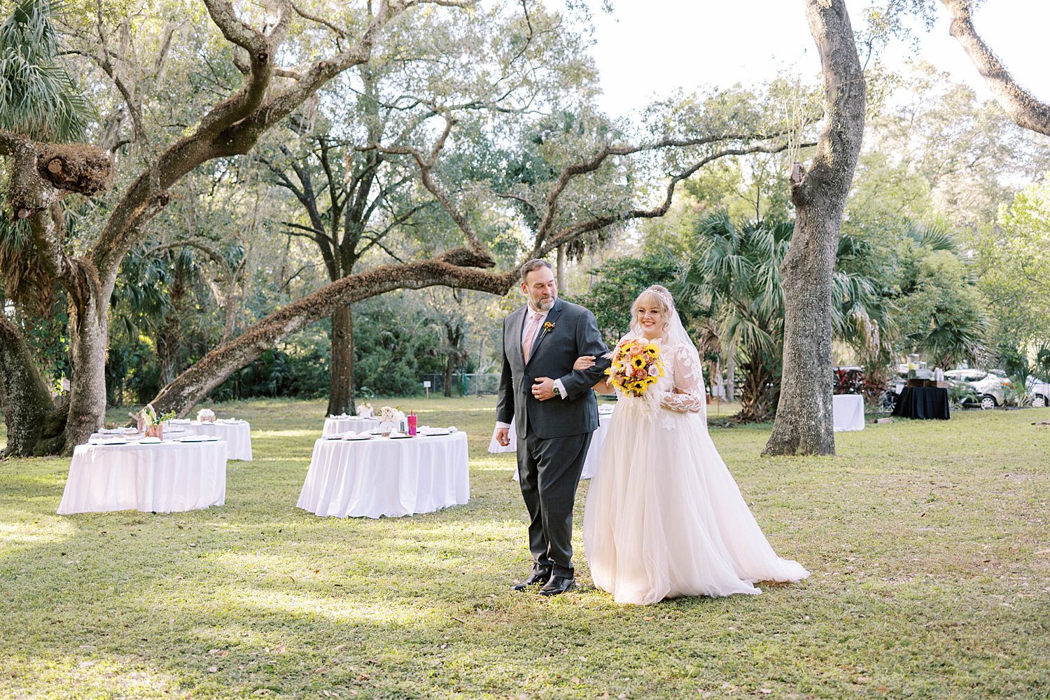 bride and dad walk into ceremony at Events Under the Oaks