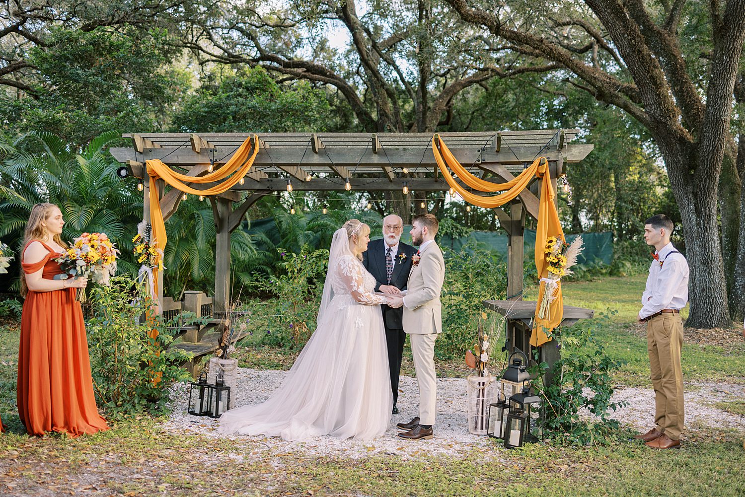 bride and groom hold hands under alter at Events Under the Oaks