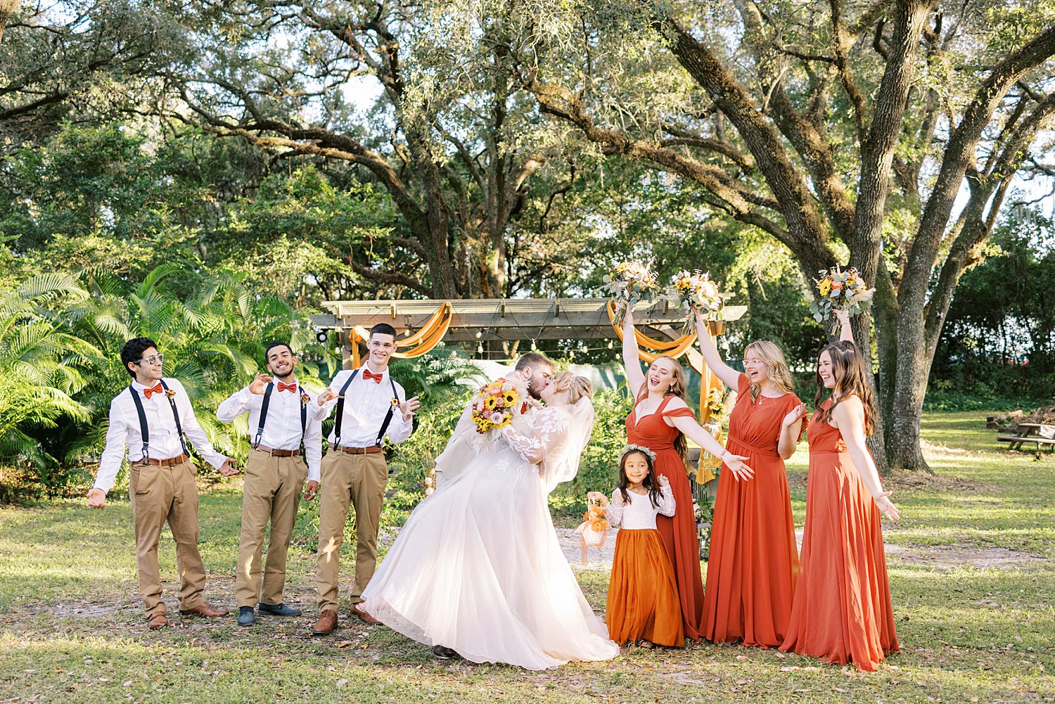 groom dips bride during ceremony at Events Under the Oaks