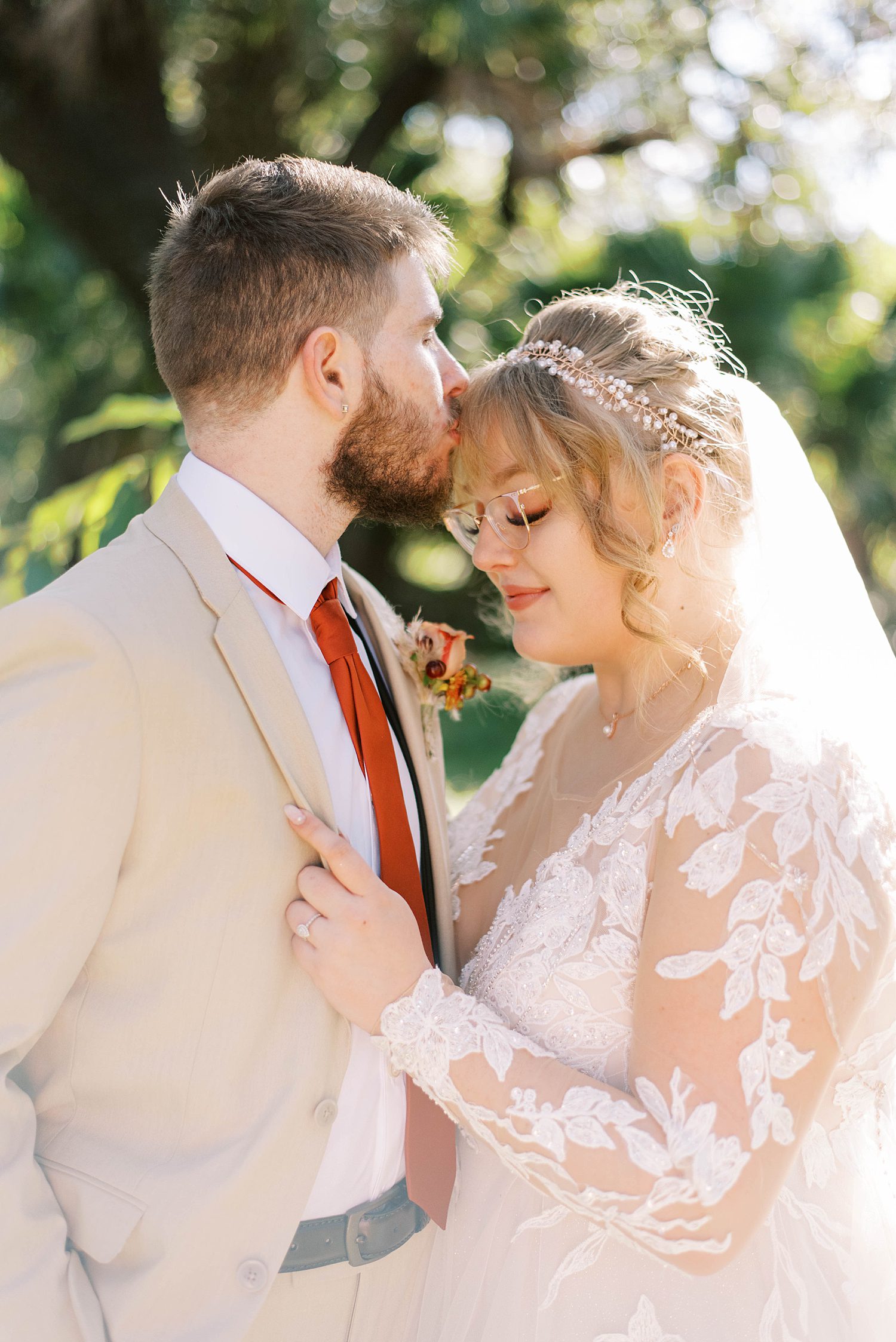 groom kisses bride's forehead during FL wedding portraits