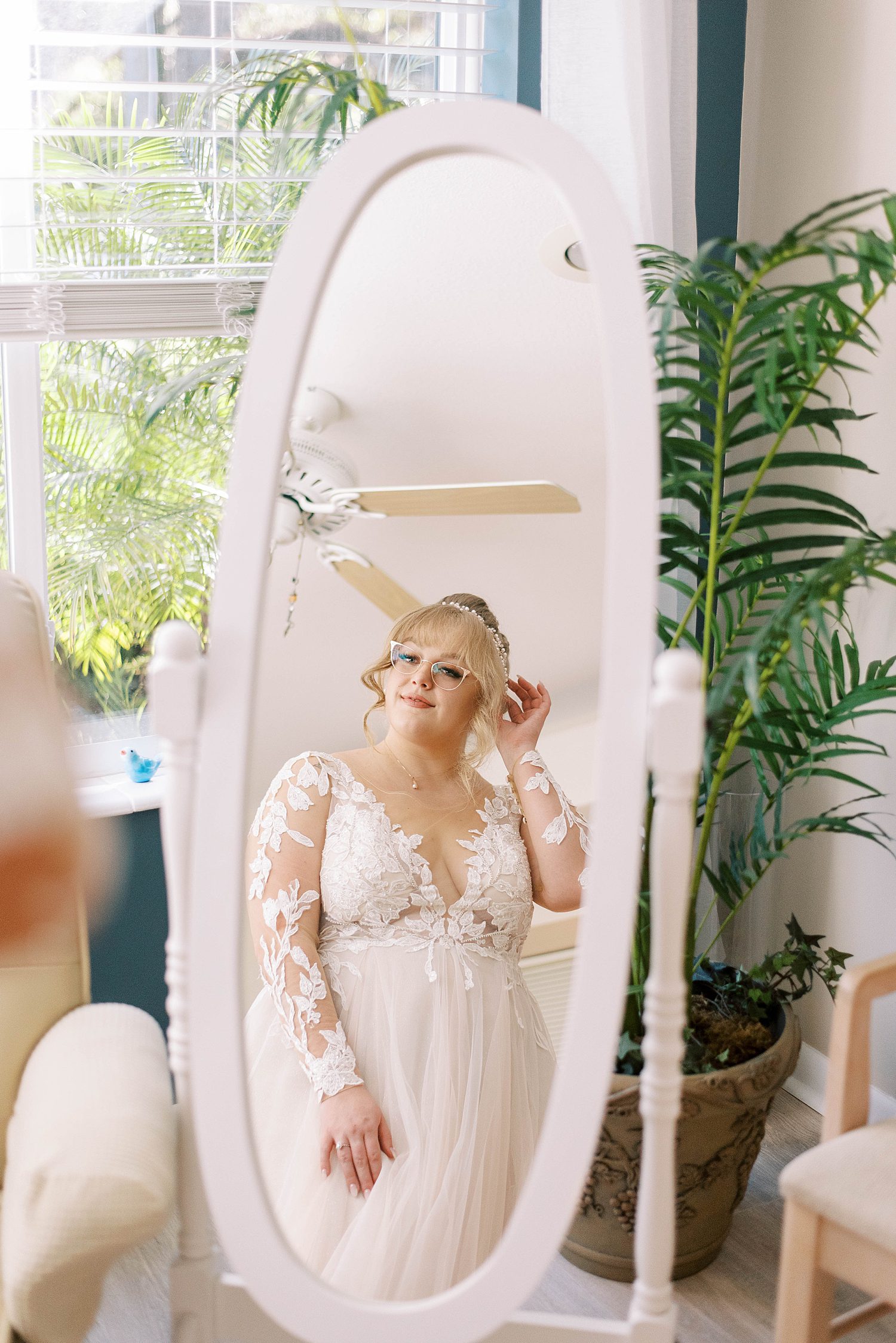 bride adjusts hair looking in mirror in Tampa FL