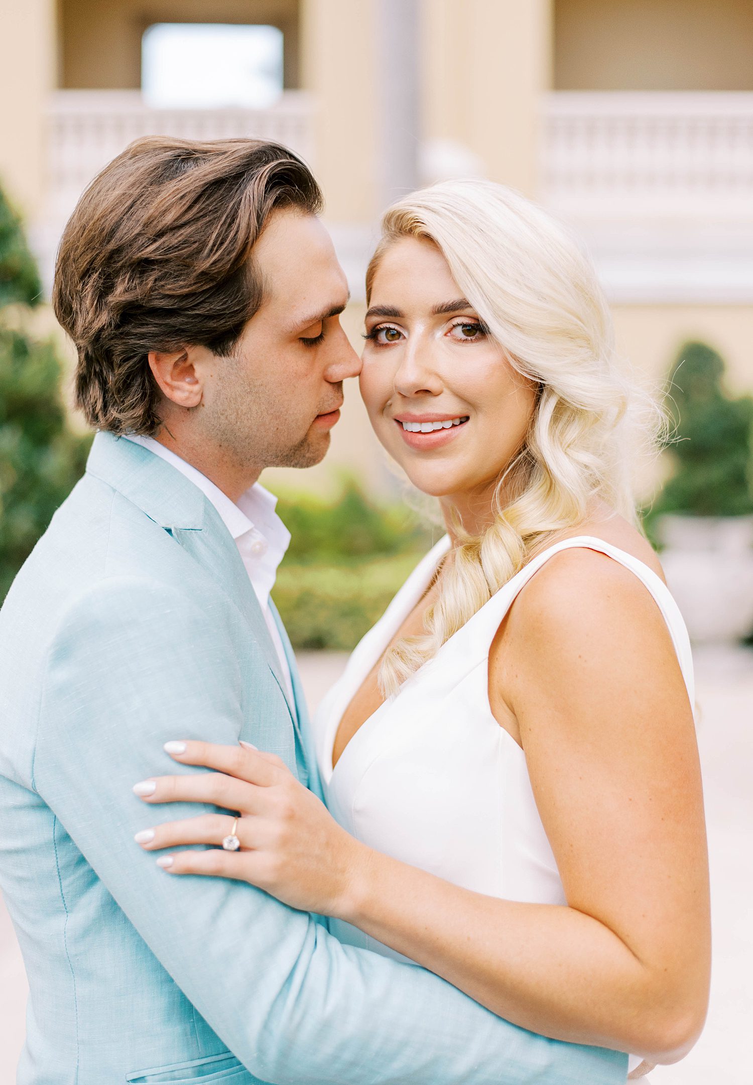 groom leans to kiss bride outside the Ritz Carlton Sarasota