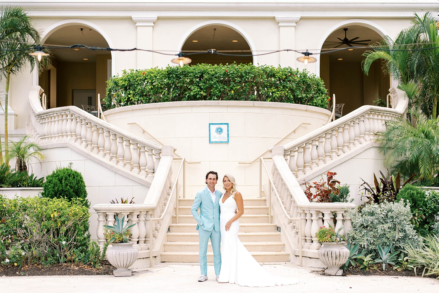 newlyweds stand at base of steps at the Ritz Carlton Sarasota