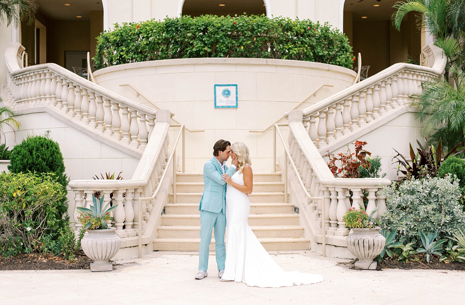 married couple hugs by staircase at Ritz Carlton Sarasota