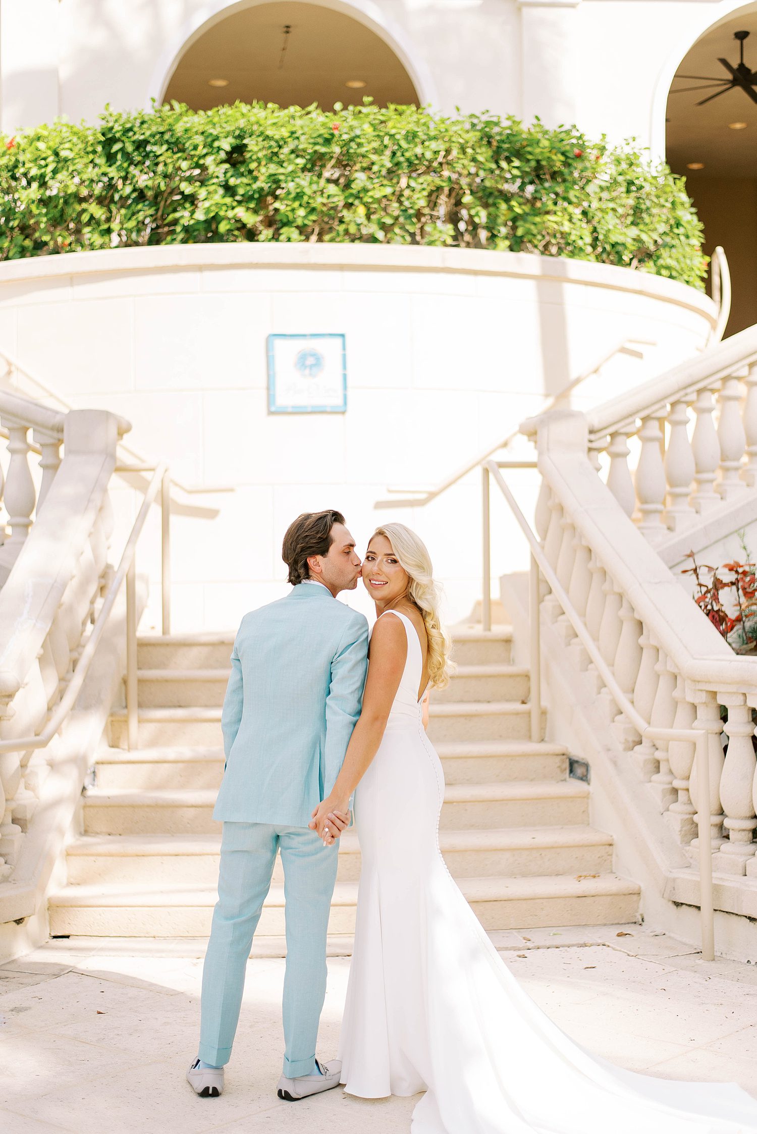 bride and groom stand at base of steps at the Ritz Carlton Sarasota