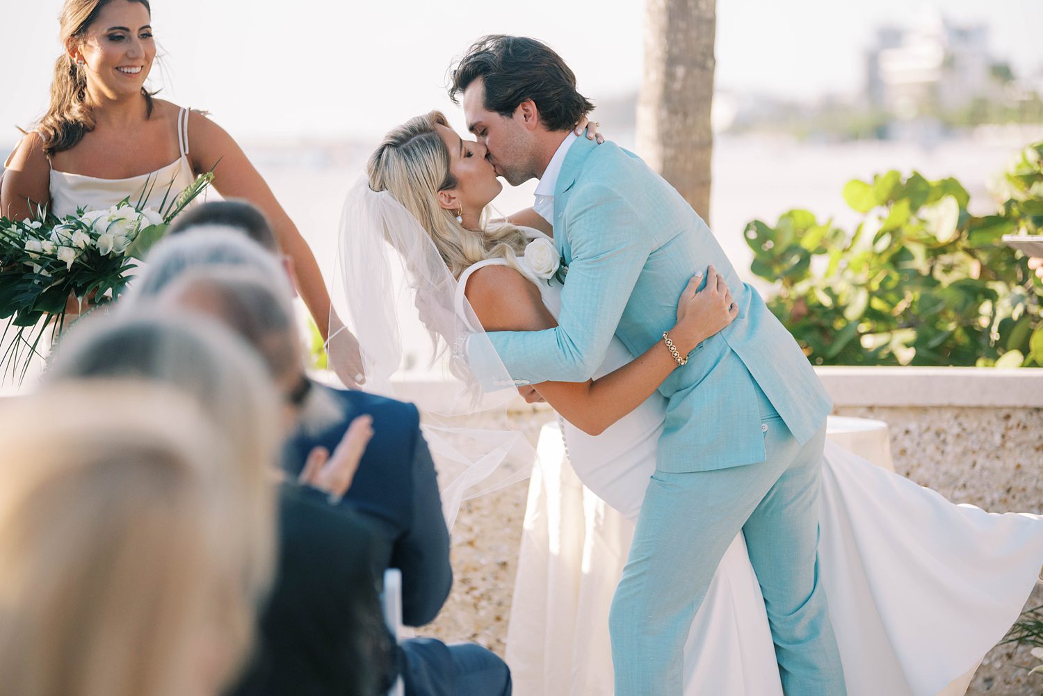 groom kisses bride in beachside ceremony dipping her backwards