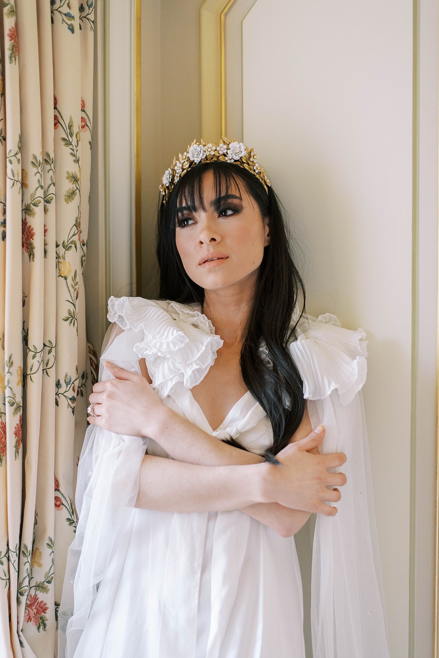 bride poses with arms crossed and gold hair piece during Paris bridal boudoir session at the Ritz