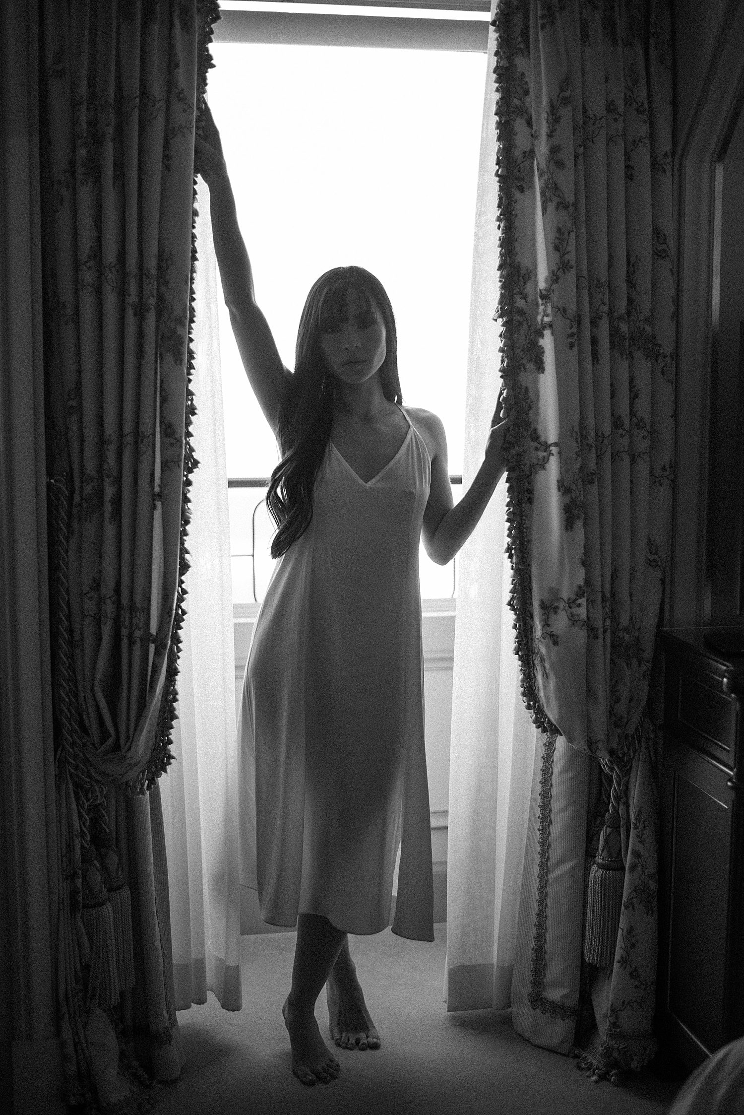 bride poses in window during Paris bridal boudoir session at the Ritz