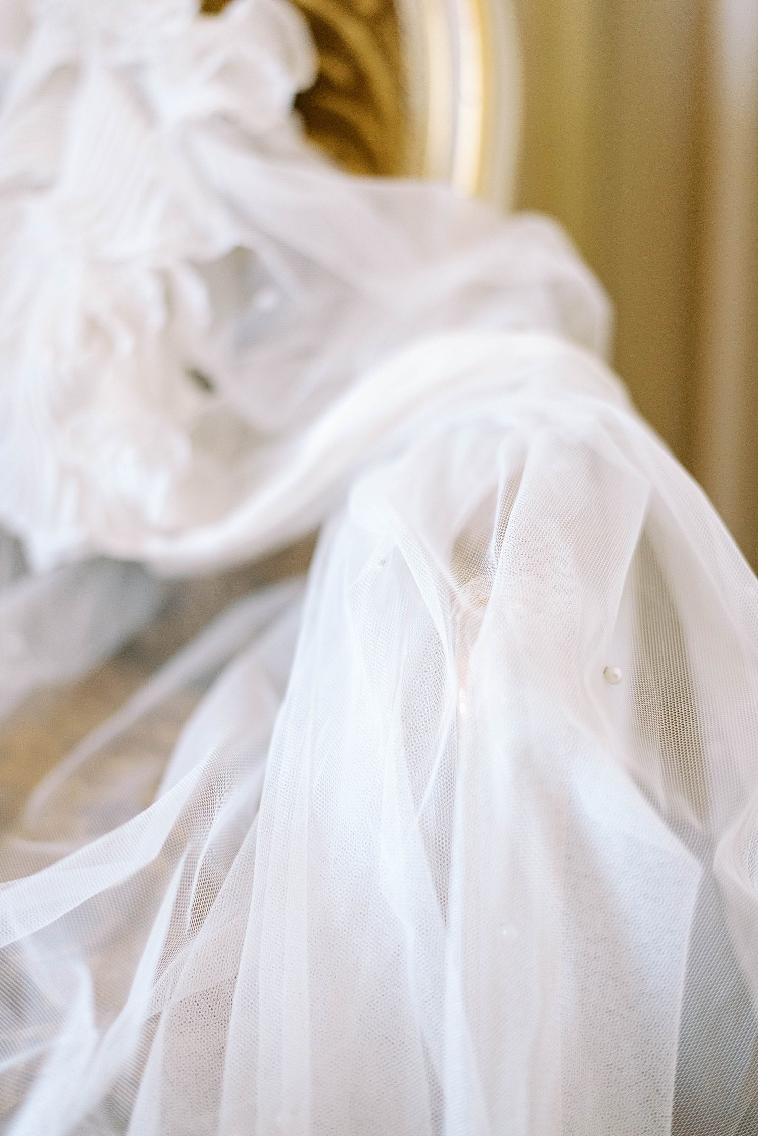 bride's gauzy robe lays on chair in Ritz Paris