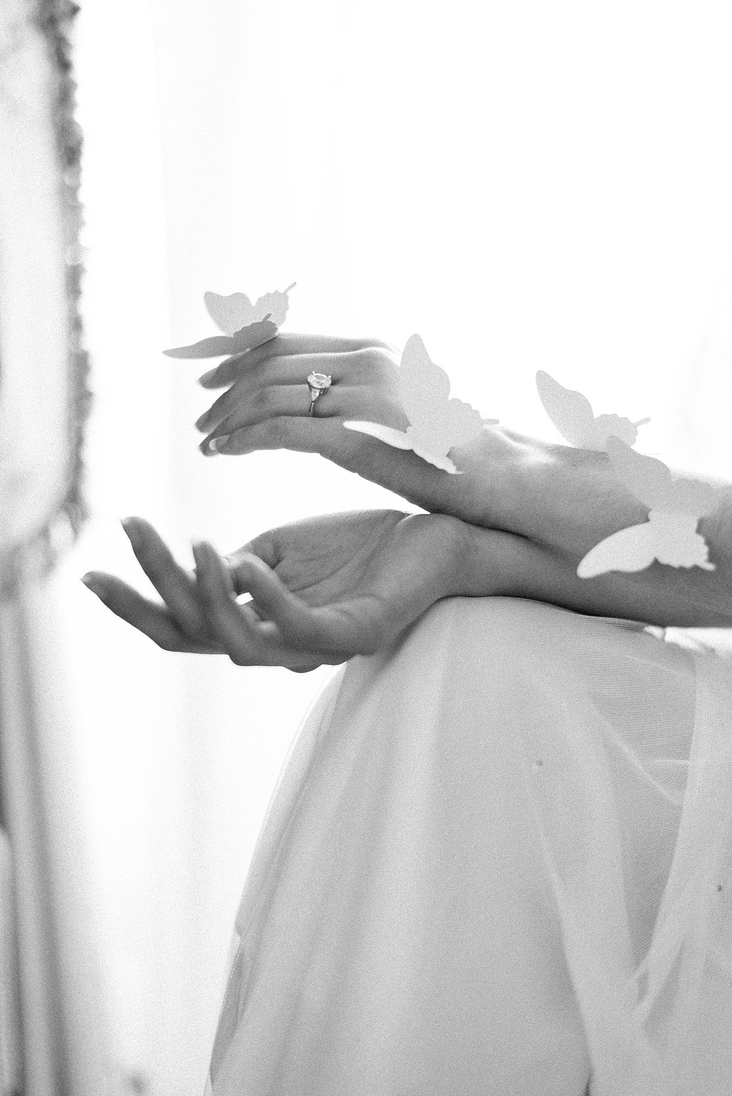 bride holds butterflies on her arm during bridal boudoir session