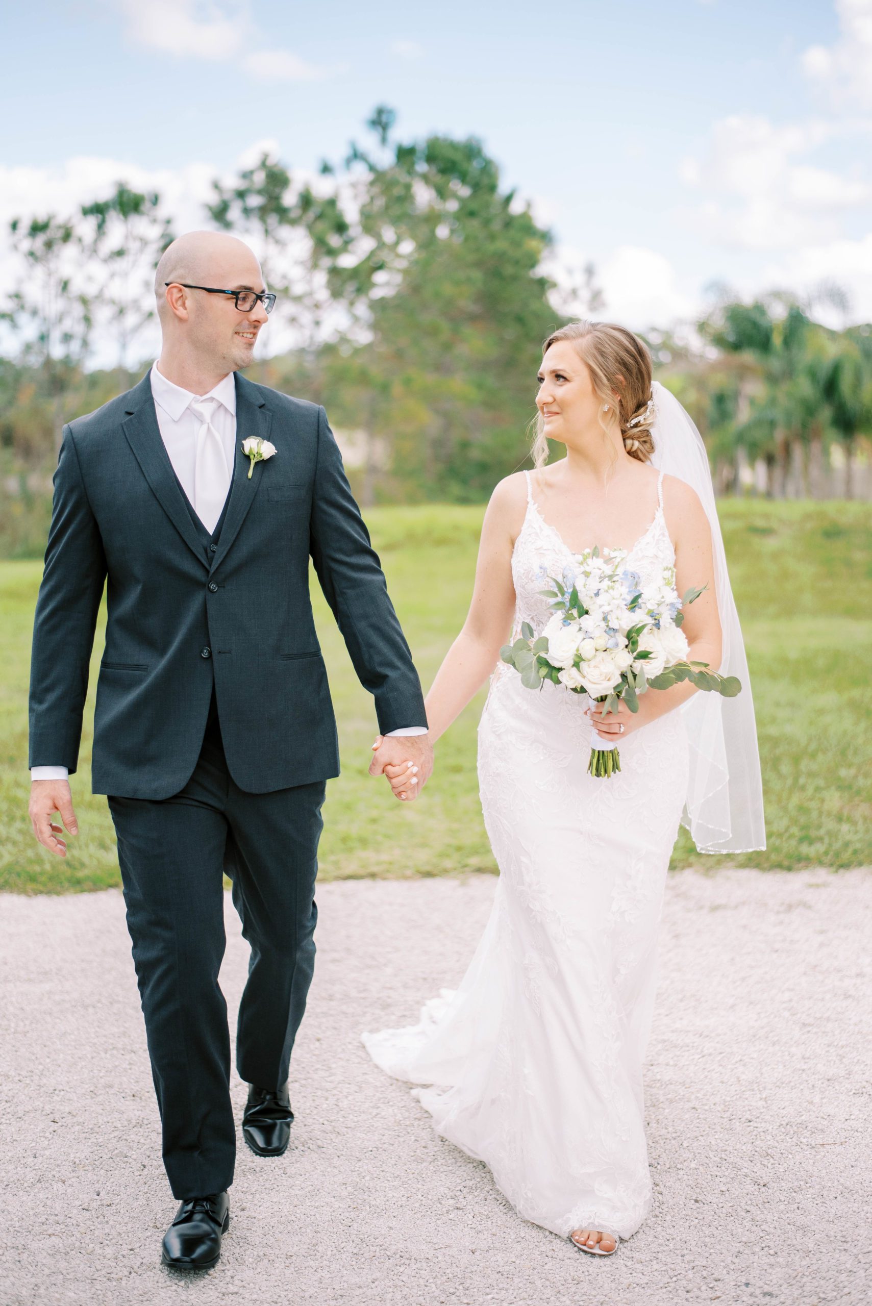 The Barn at Lone oak acres wedding Tampa wedding bride and groom walking holding hands and smiling