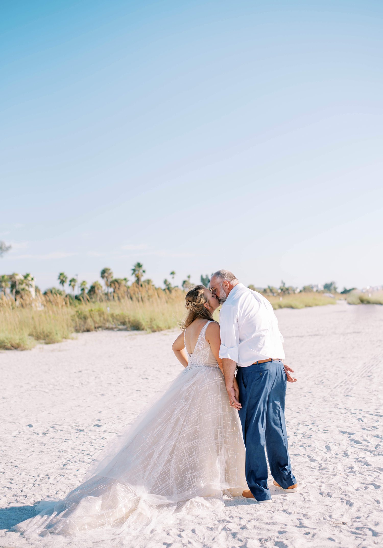 newlyweds kiss on beach during Tampa FL wedding day