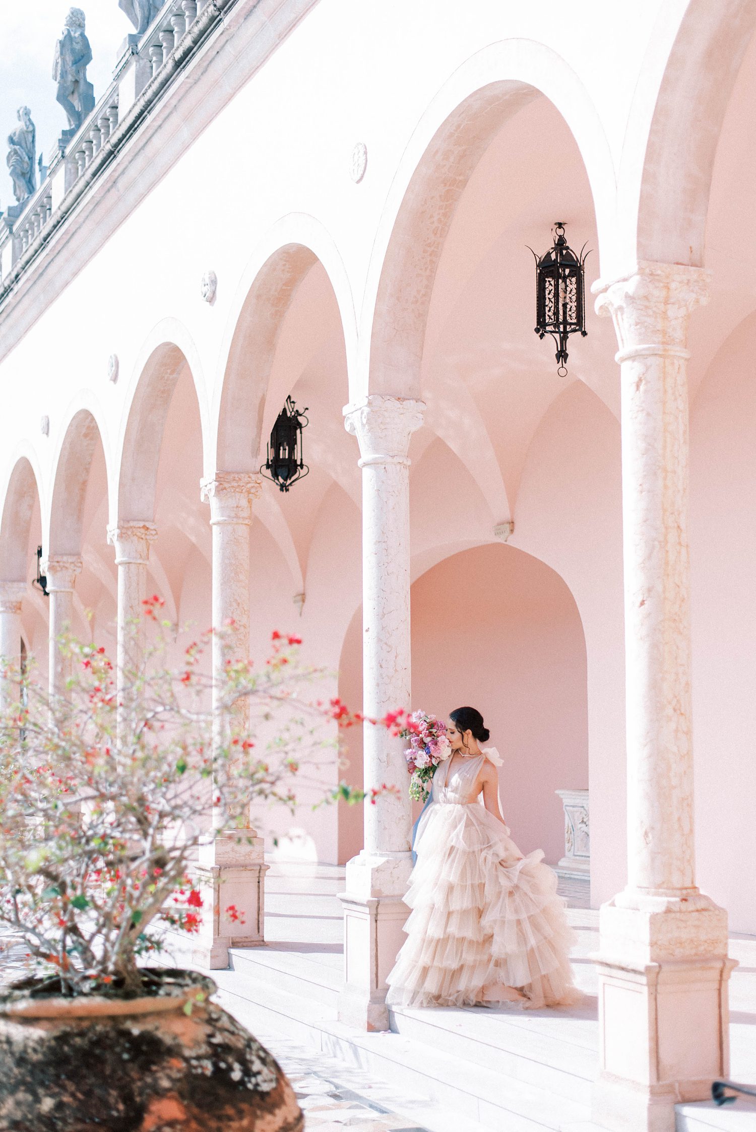 bride in pink gown poses in arches at The Ringling Museum