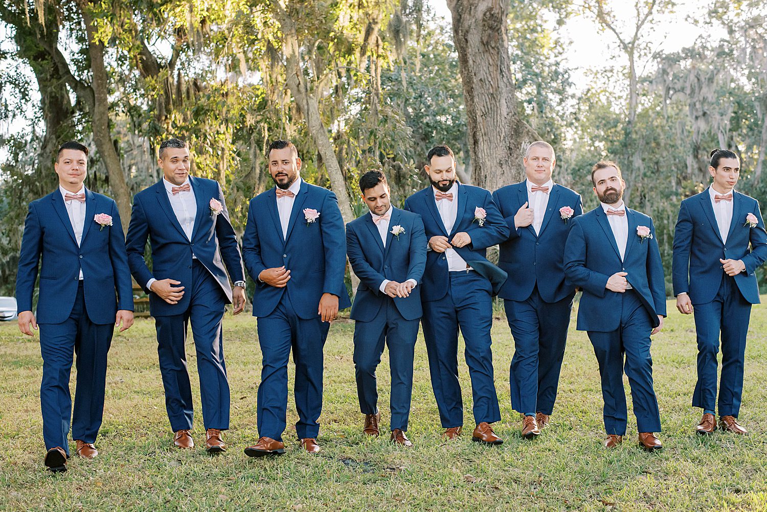 groom walks with groomsmen in navy suits