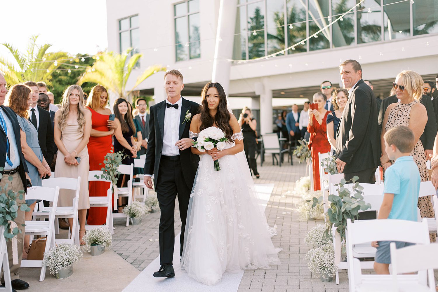 bride walks down aisle with father at Sarasota Yacht Club