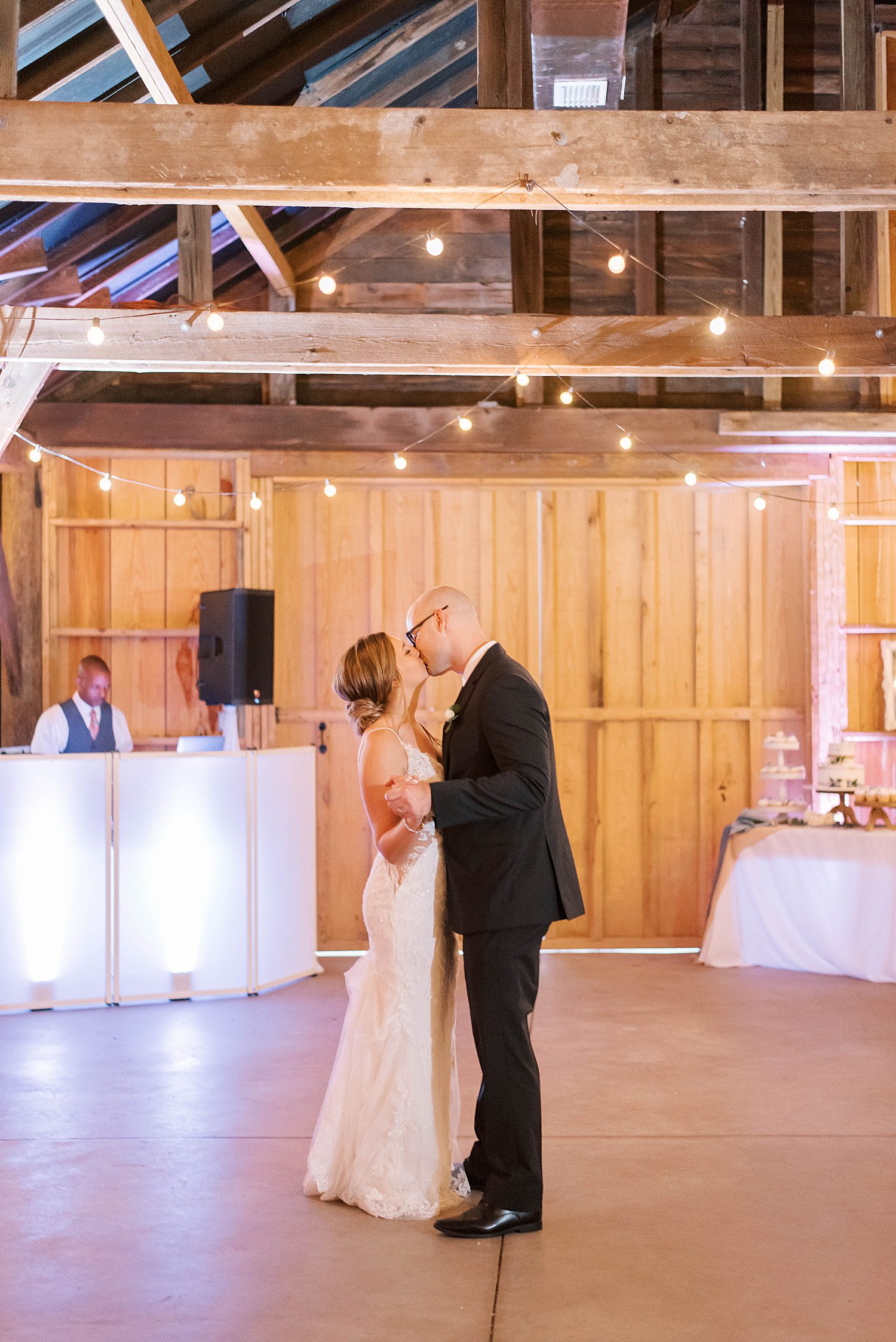 bride and groom kiss on dance floor at The Barn at Lone Oak Acres