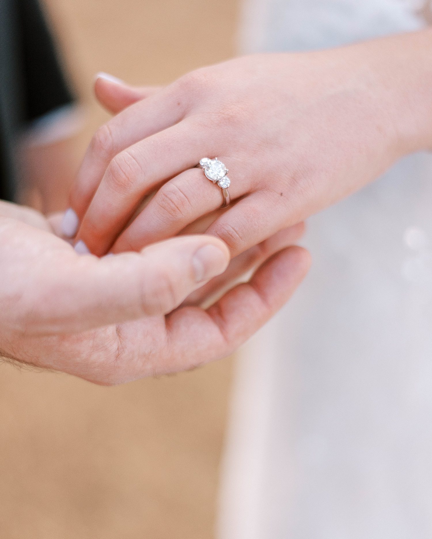 groom holds bride's hand showing off heirloom engagement ring