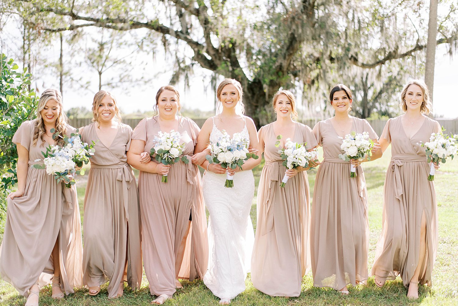 bride walks with bridesmaids in champagne gowns in Tampa FL