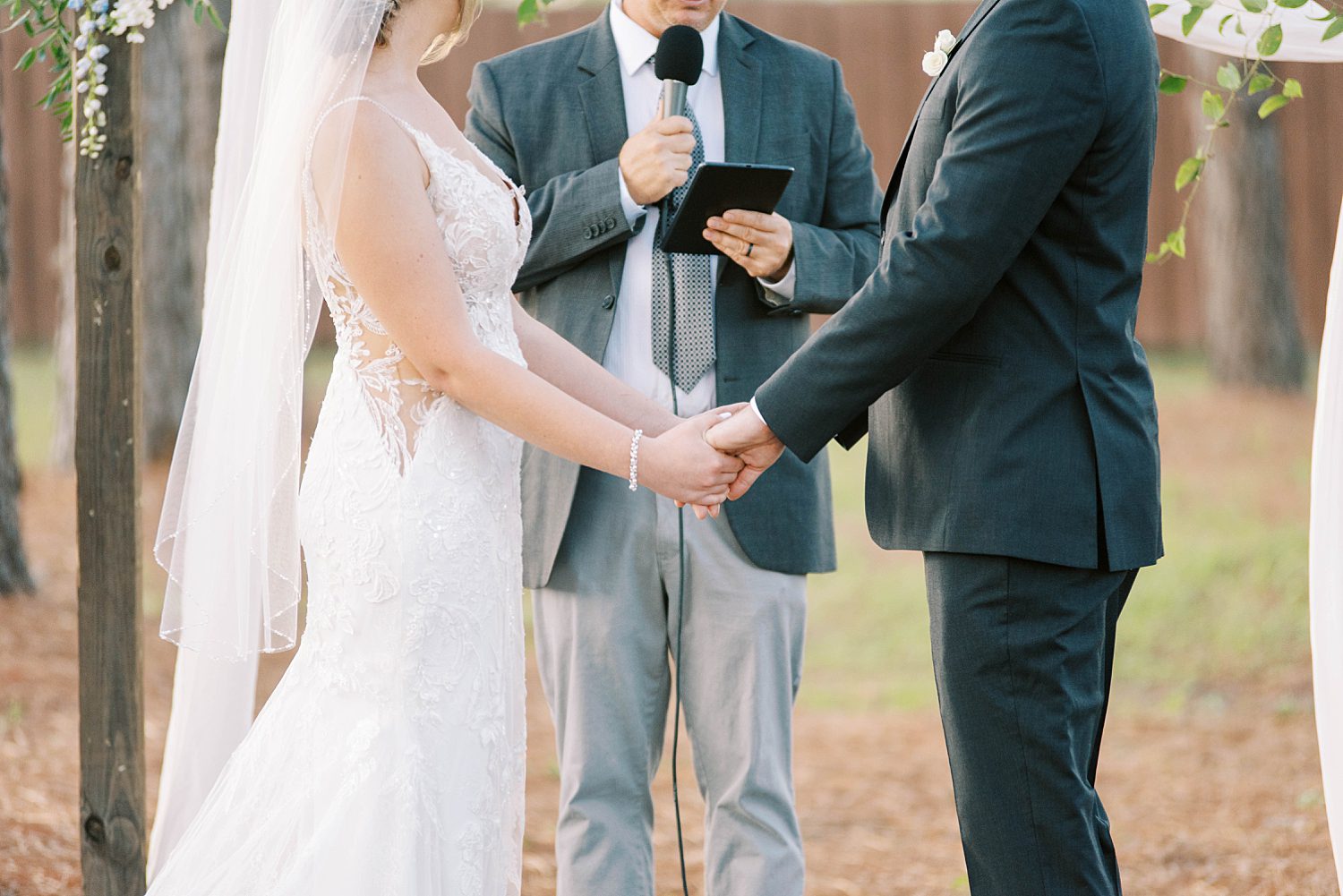 bride and groom hold hands during wedding ceremony