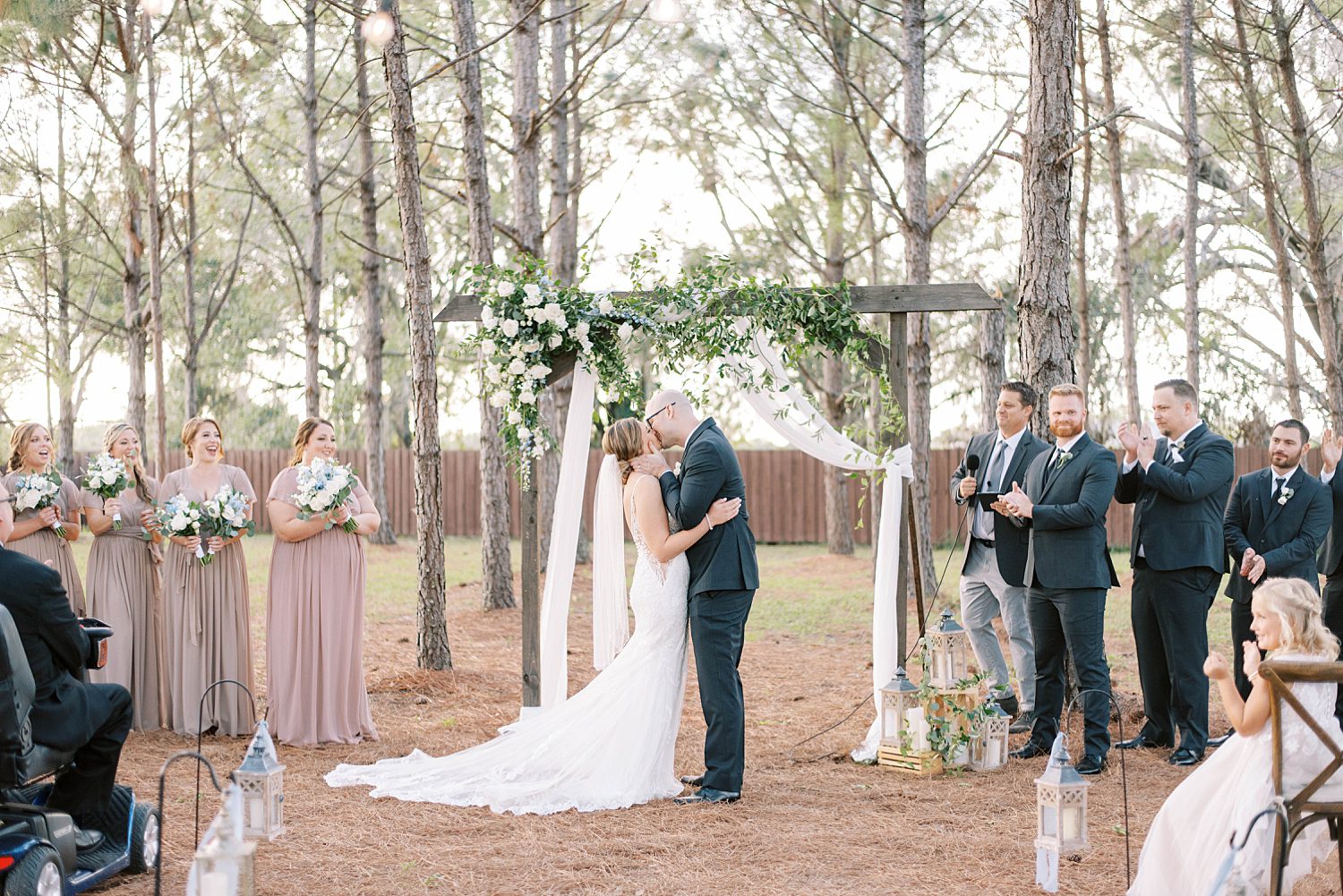 bride and groom kiss during outdoor wedding ceremony