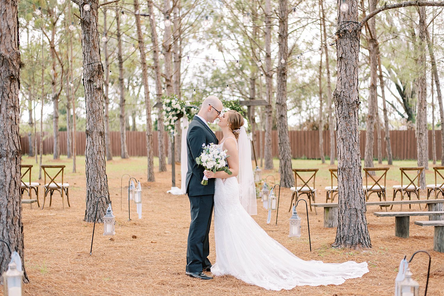 bride and groom hug in aisle at ceremony space with wooden pews