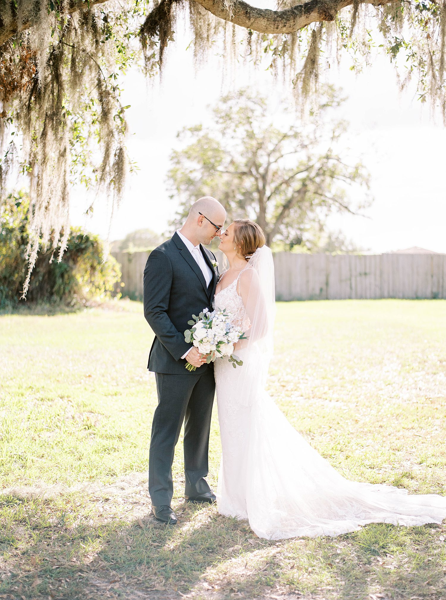 bride and groom kiss at lawn at The Barn at Lone Oak Acres