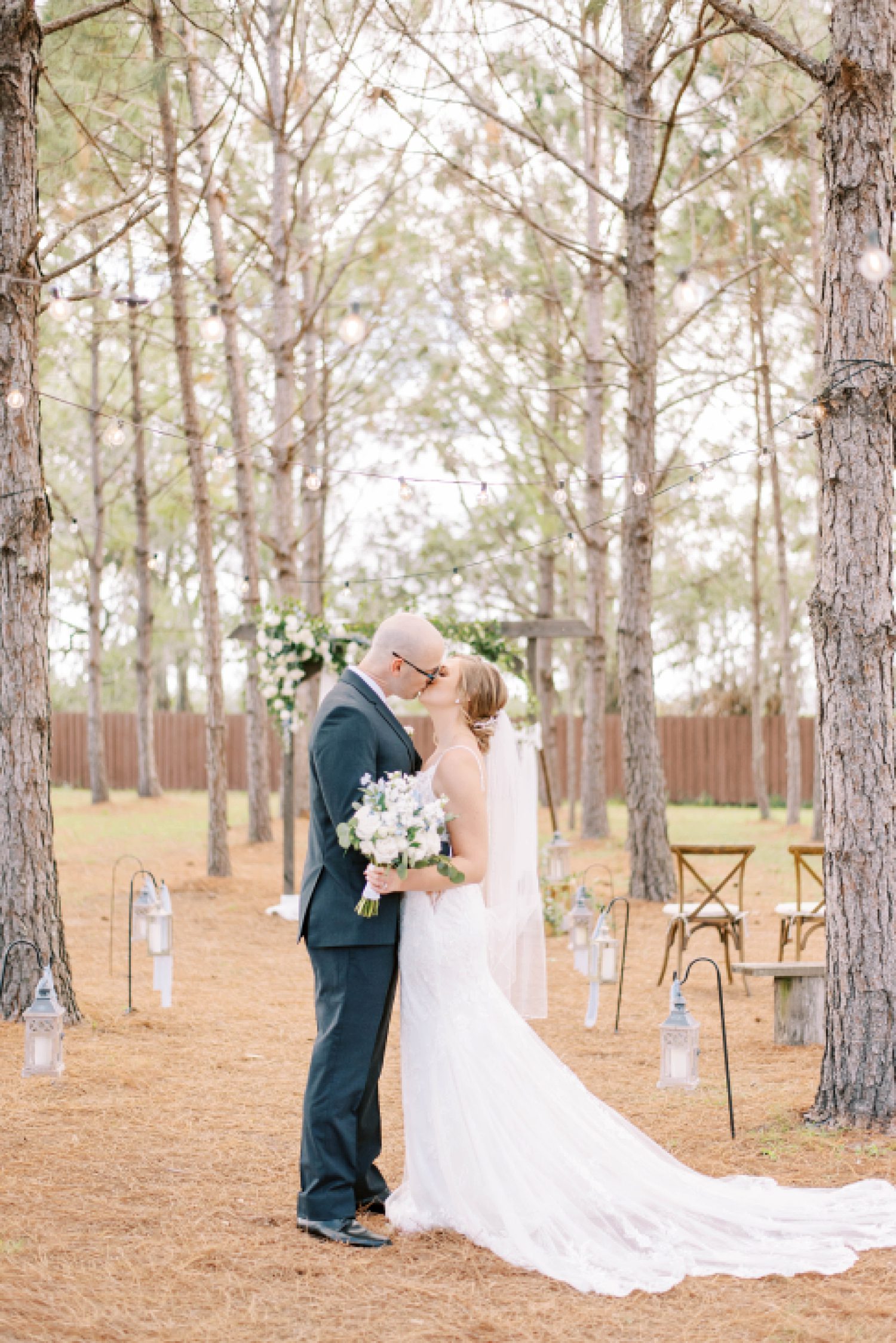 bride and groom kiss in aisle at ceremony site at The Barn at Lone Oak Acres