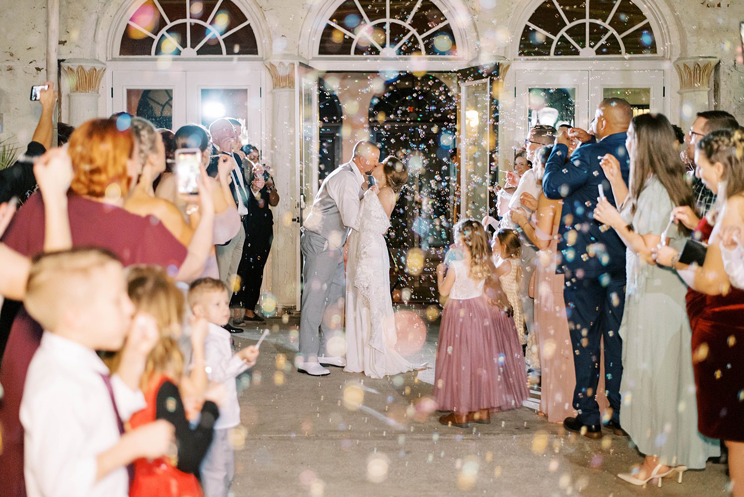 newlyweds kiss after bubble exit outside Bella Cosa Lakeside wedding