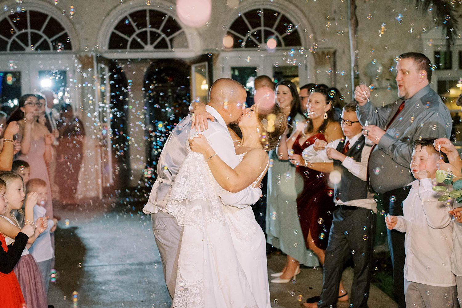 bride and groom kiss during bubble exit outside Bella Cosa Lakeside