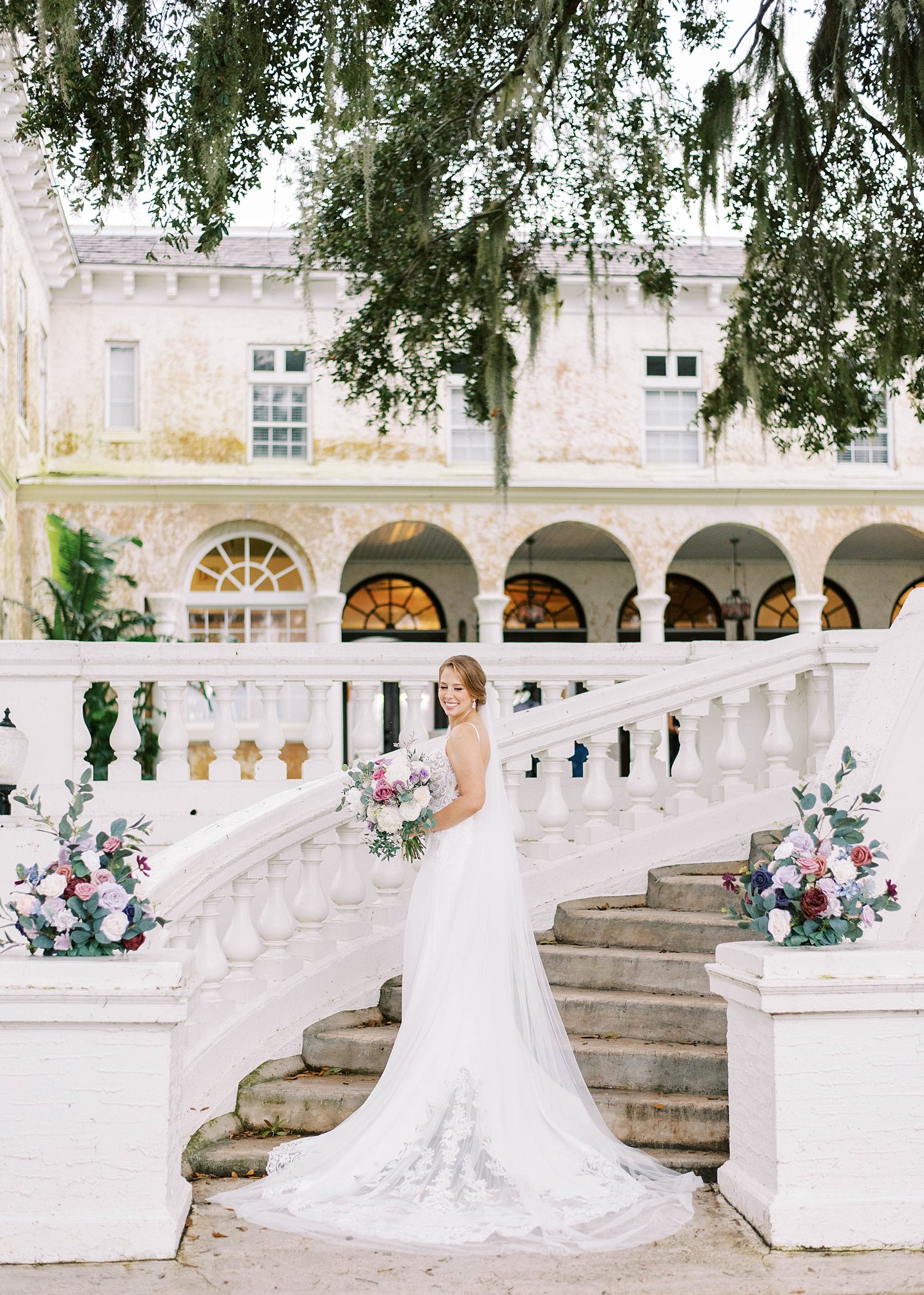 bride poses on steps of stairway at Bella Cosa Lakeside